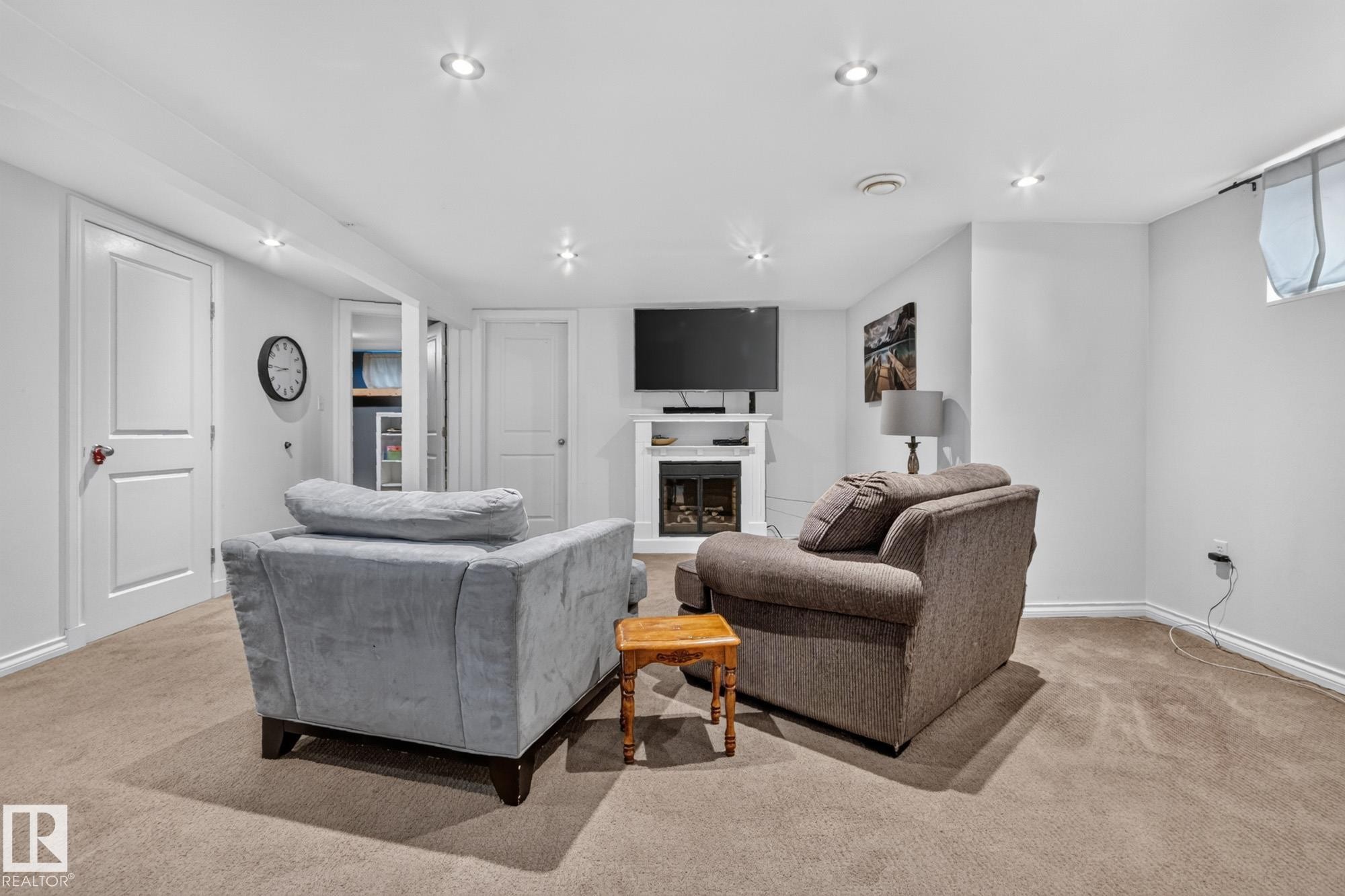 Finished lower level featuring recessed lighting and carpeted flooring - 5307 104 Avenue Nw, Edmonton, AB - Indoor Photo Showing Living Room With Fireplace
