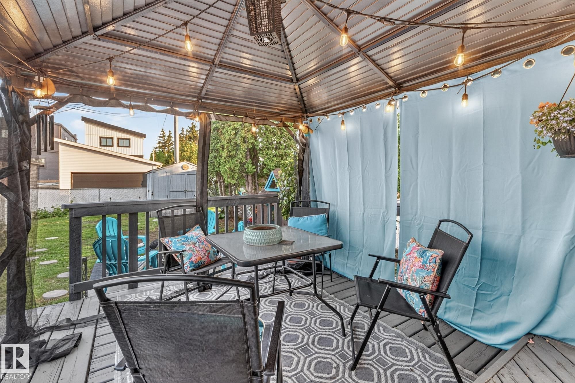 Covered deck featuring a textured metal roof and integrated string lighting - 5307 104 Avenue Nw, Edmonton, AB - Outdoor With Deck Patio Veranda With Exterior