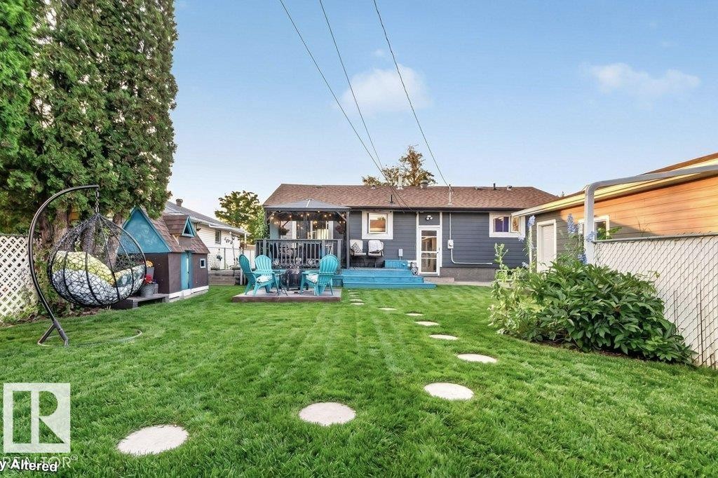 Expansive backyard featuring a lush lawn, stepping stone pathway, and mature perimeter trees - 5307 104 Avenue Nw, Edmonton, AB - Outdoor