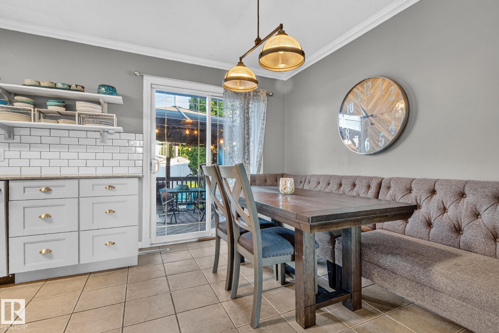 Dining area featuring a tufted banquette, a dark wood-finish table, and tile flooring - 5307 104 Avenue Nw, Edmonton, AB - Indoor Photo Showing Dining Room