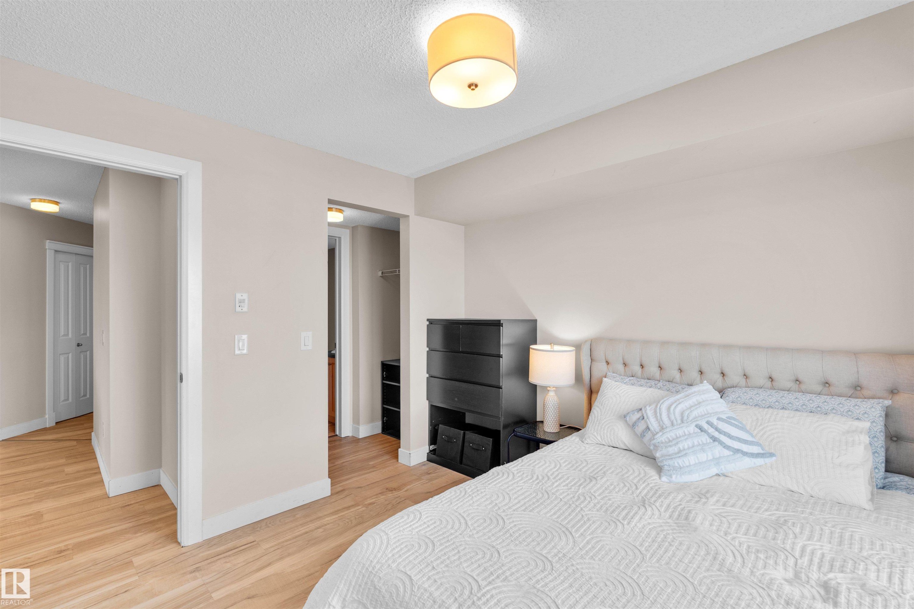 Bedroom featuring light wood-finish flooring, neutral wall tones, and white trim - #317 3719 Whitelaw Ln Nw, Edmonton, AB - Indoor Photo Showing Bedroom