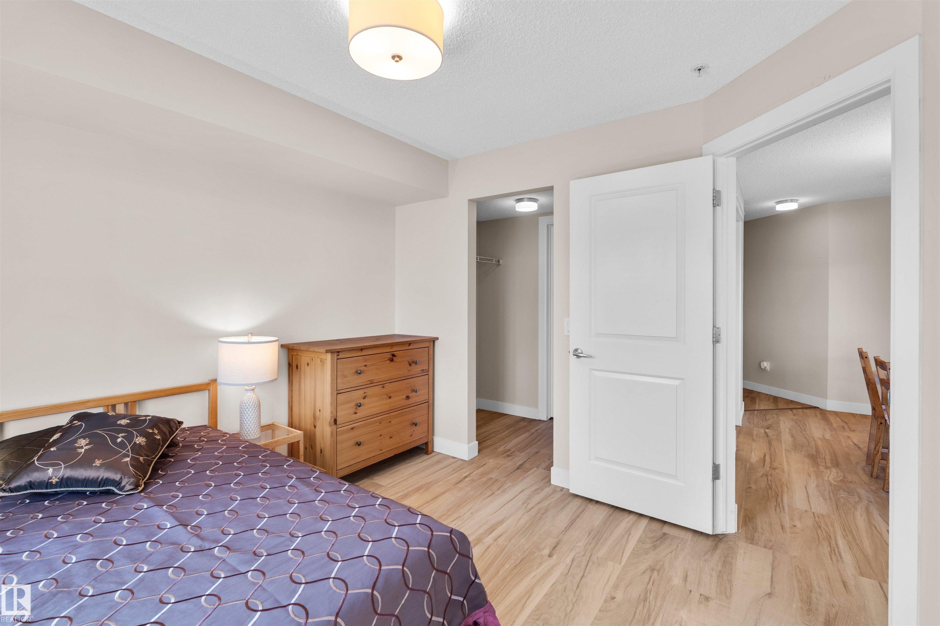 Bedroom with light wood-finish flooring, white trim, and a semi-flush ceiling light fixture - #317 3719 Whitelaw Ln Nw, Edmonton, AB - Indoor Photo Showing Bedroom