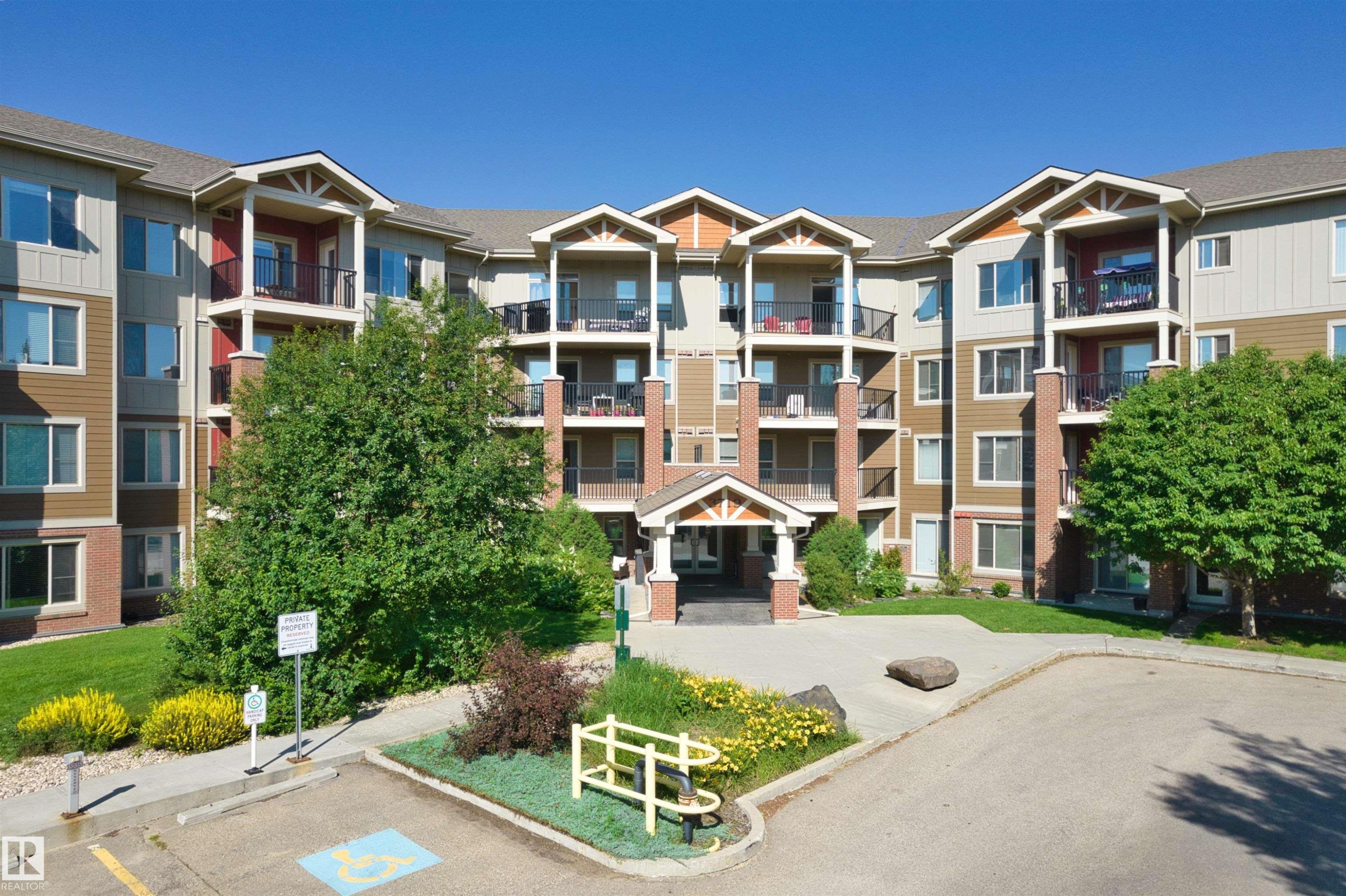 Multi-story building with a central portico entrance - #317 3719 Whitelaw Ln Nw, Edmonton, AB - Outdoor With Balcony With Facade