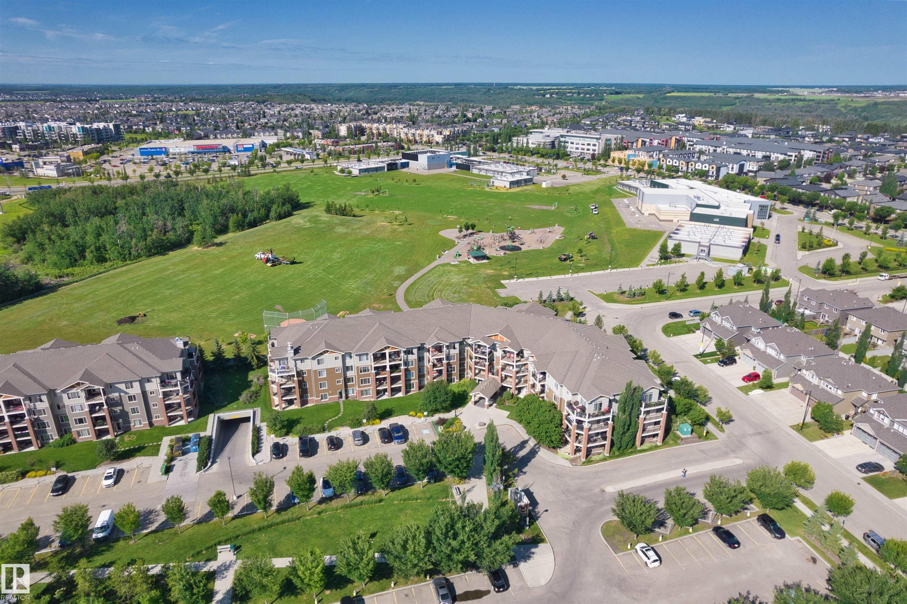 Multi-story residential complex featuring private balconies, surface parking, and underground parking access - #317 3719 Whitelaw Ln Nw, Edmonton, AB - Outdoor With View