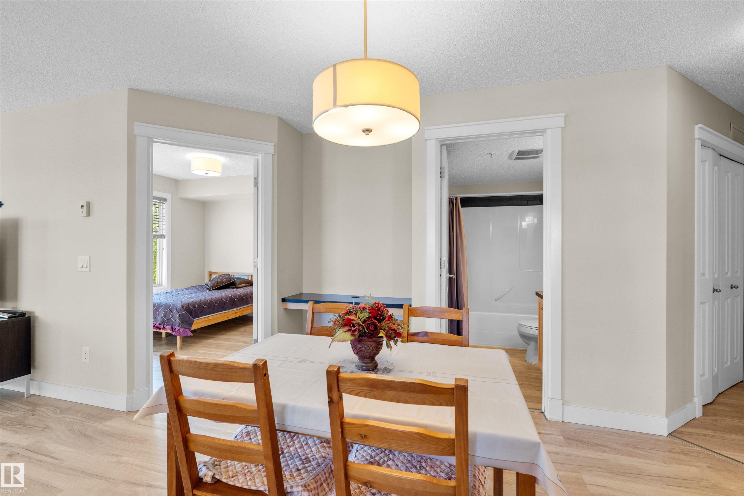 Dining area featuring light wood-finish flooring and a drum-style ceiling light - #317 3719 Whitelaw Ln Nw, Edmonton, AB - Indoor Photo Showing Dining Room