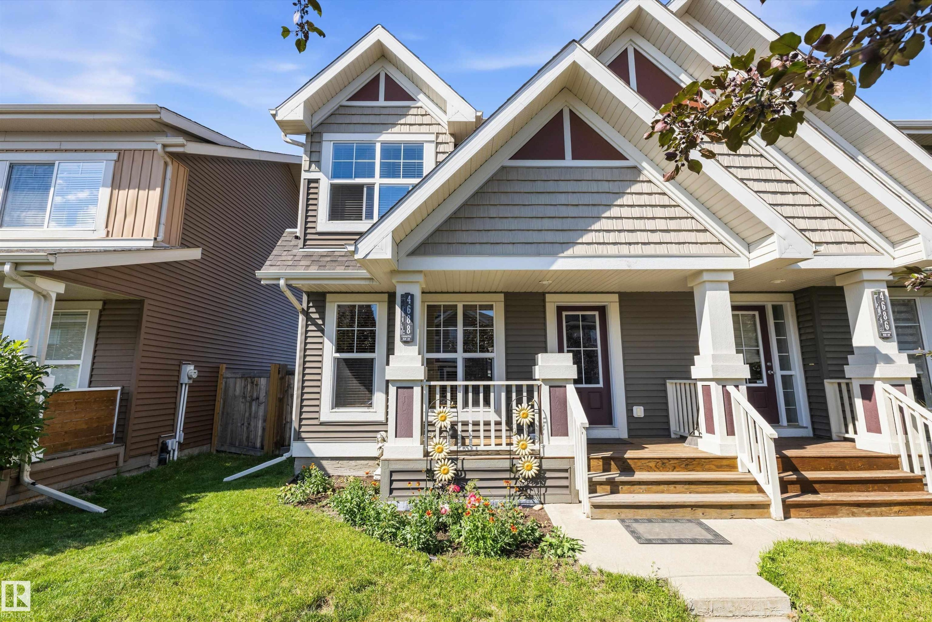 Front exterior featuring a covered porch, wood-finish steps, and a gabled roofline with shake siding accents - 4688 Crabapple Run Sw, Edmonton, AB - Outdoor With Deck Patio Veranda With Facade