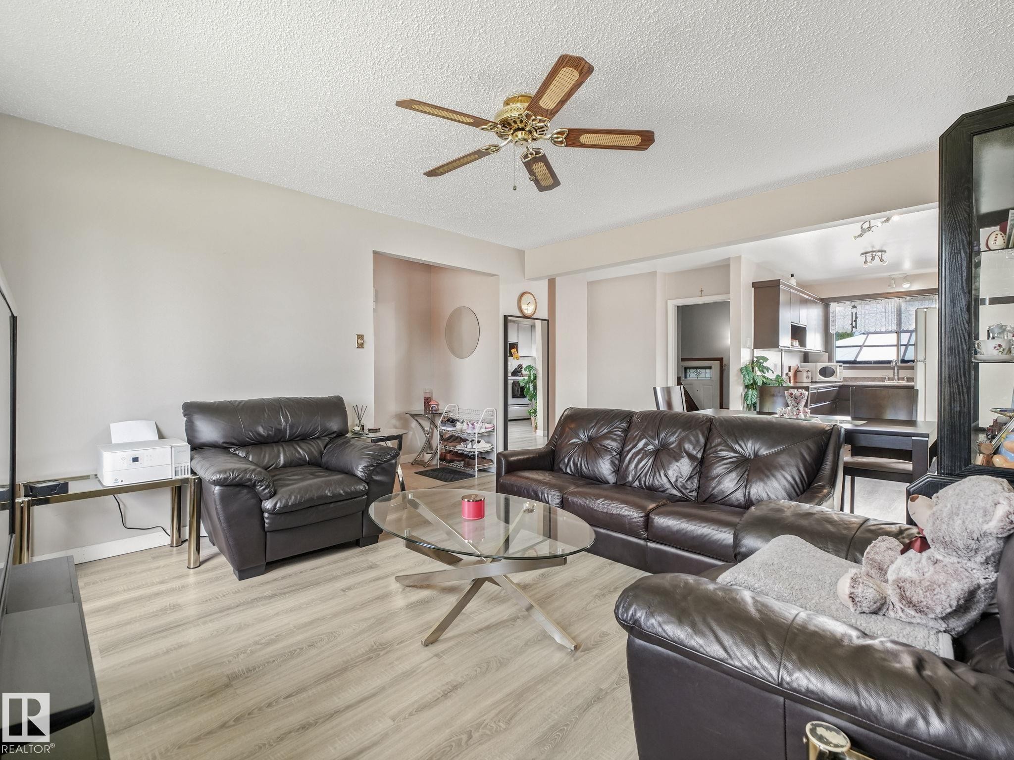 Spacious living area featuring light wood-finish flooring and neutral wall tones - 13323 58 Street Nw, Edmonton, AB - Indoor Photo Showing Living Room