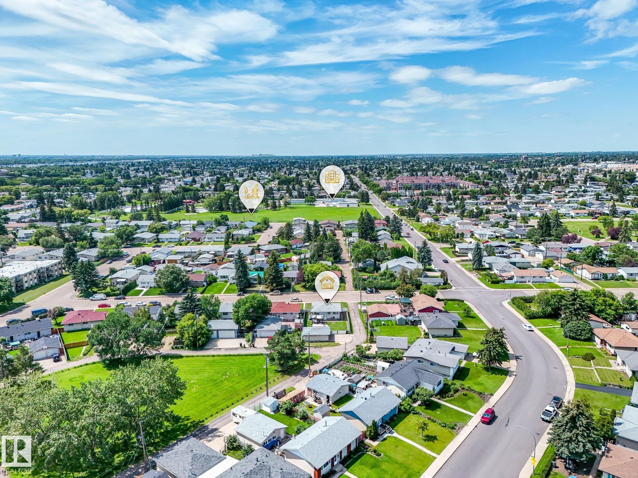 Aerial perspective showcasing a residential neighborhood with established homes, green spaces, and connecting roadways - 13323 58 Street Nw, Edmonton, AB - Outdoor With View
