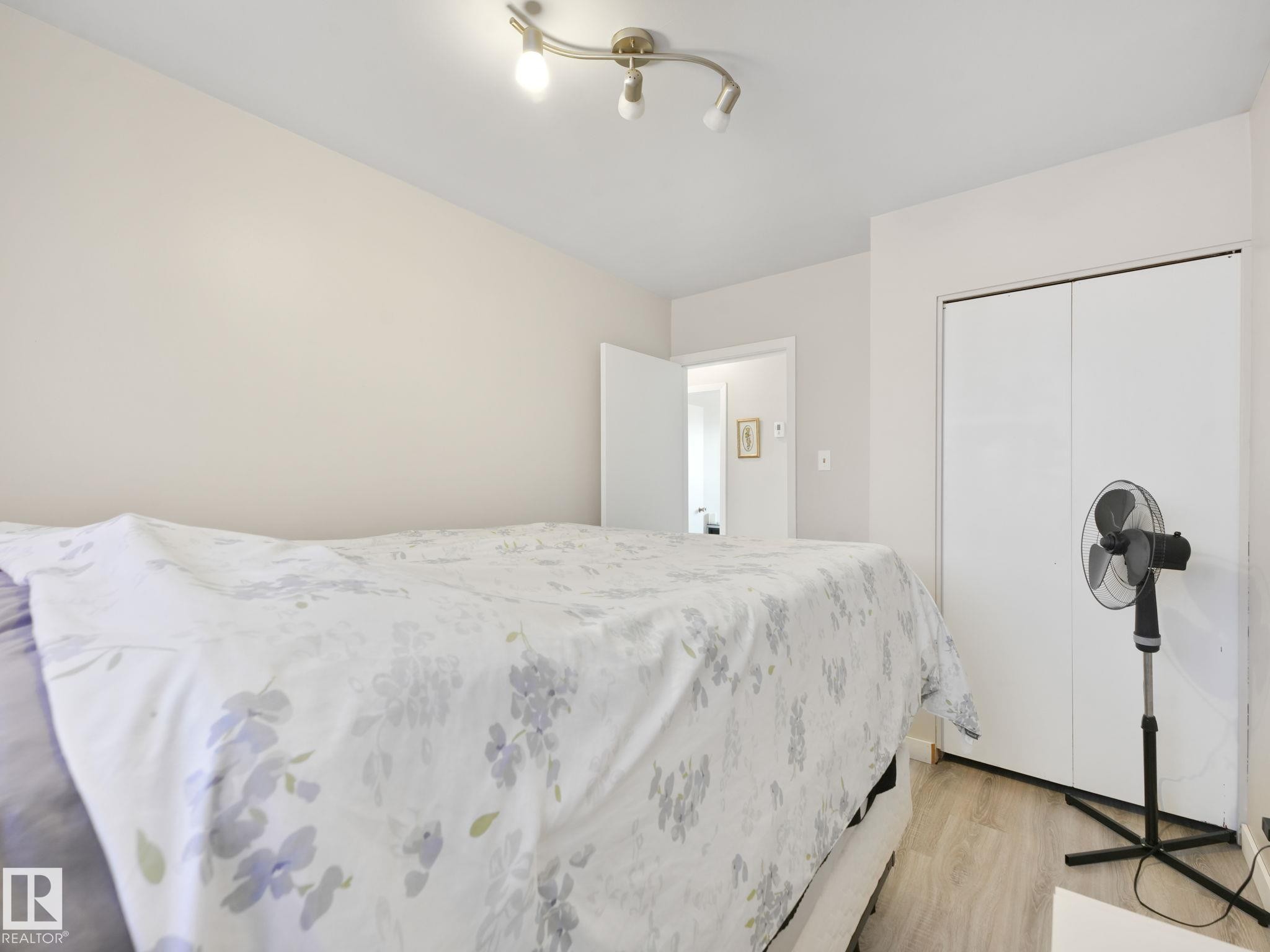 Bedroom featuring light-toned walls, track lighting, and wood-finish flooring - 13323 58 Street Nw, Edmonton, AB - Indoor Photo Showing Bedroom
