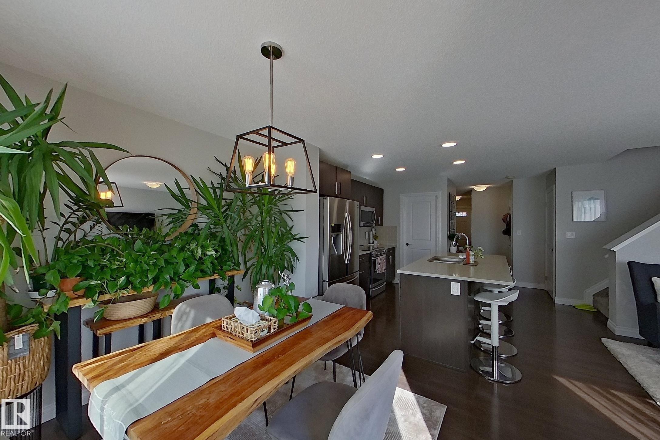 Open-concept living area featuring dark wood-finish flooring - 491 Ebbers Way, Edmonton, AB