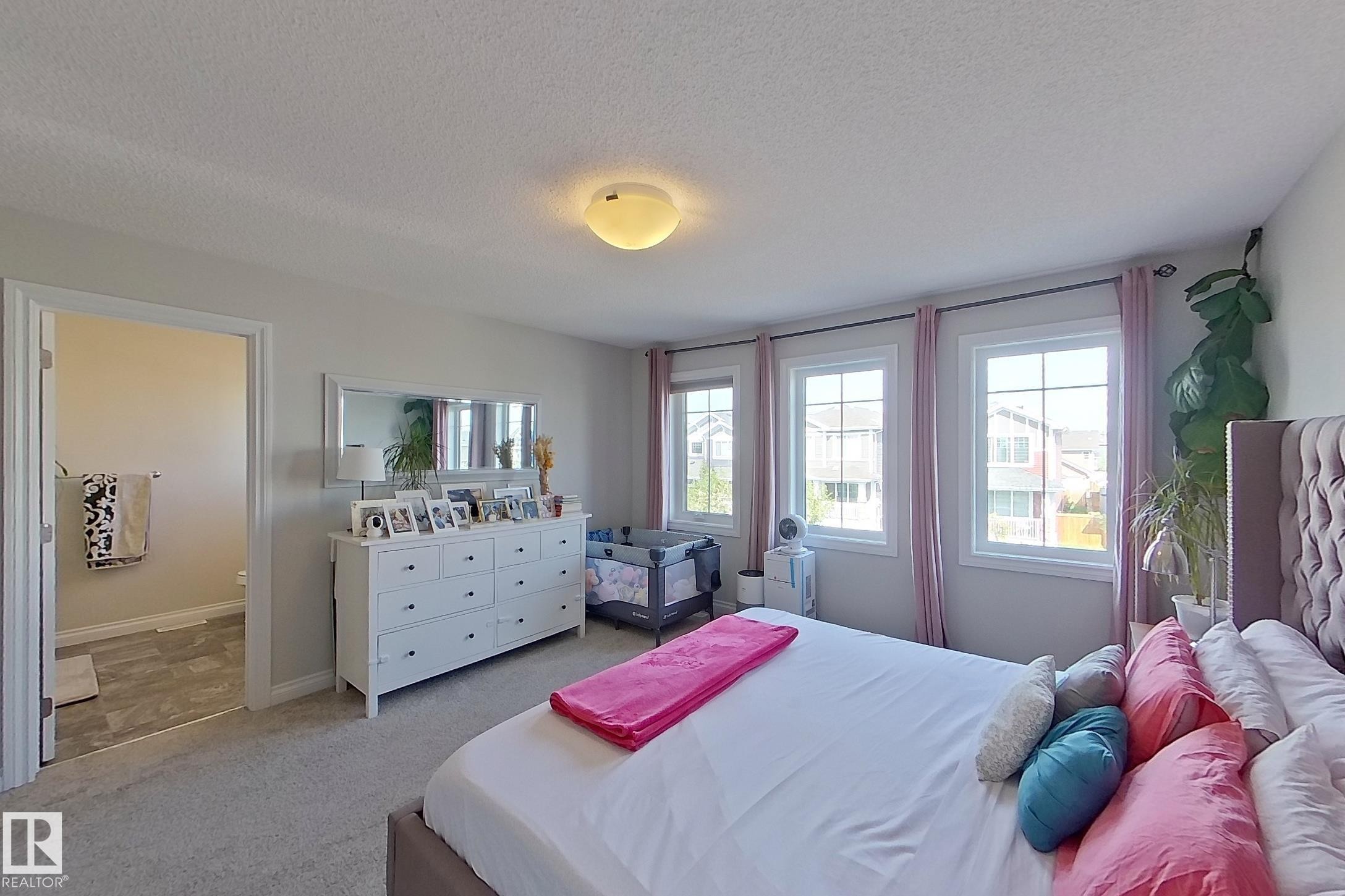 Spacious bedroom with light gray wall paint and carpet flooring - 491 Ebbers Way, Edmonton, AB