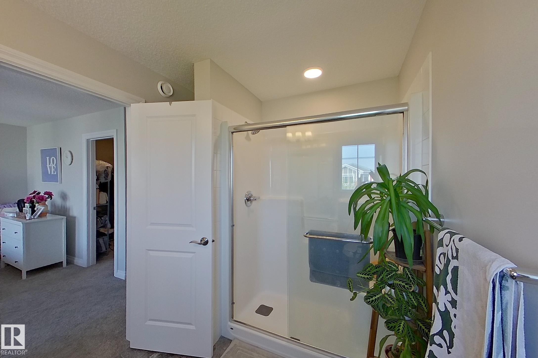 Shower enclosure with clear glass door, chrome hardware, and recessed ceiling lighting - 491 Ebbers Way, Edmonton, AB