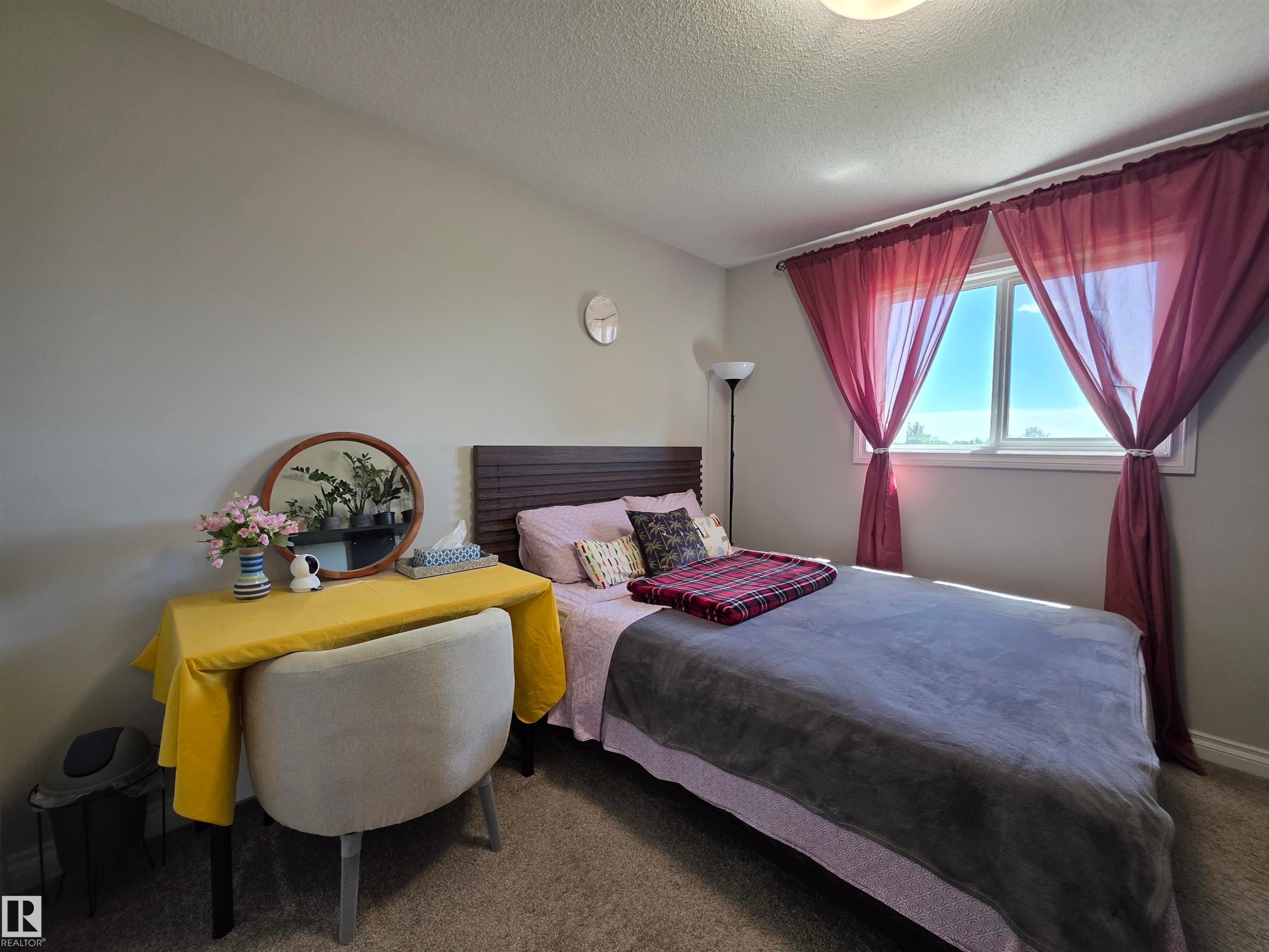 Bedroom featuring a window with natural light, light gray wall paint, and textured carpeting - 491 Ebbers Way, Edmonton, AB
