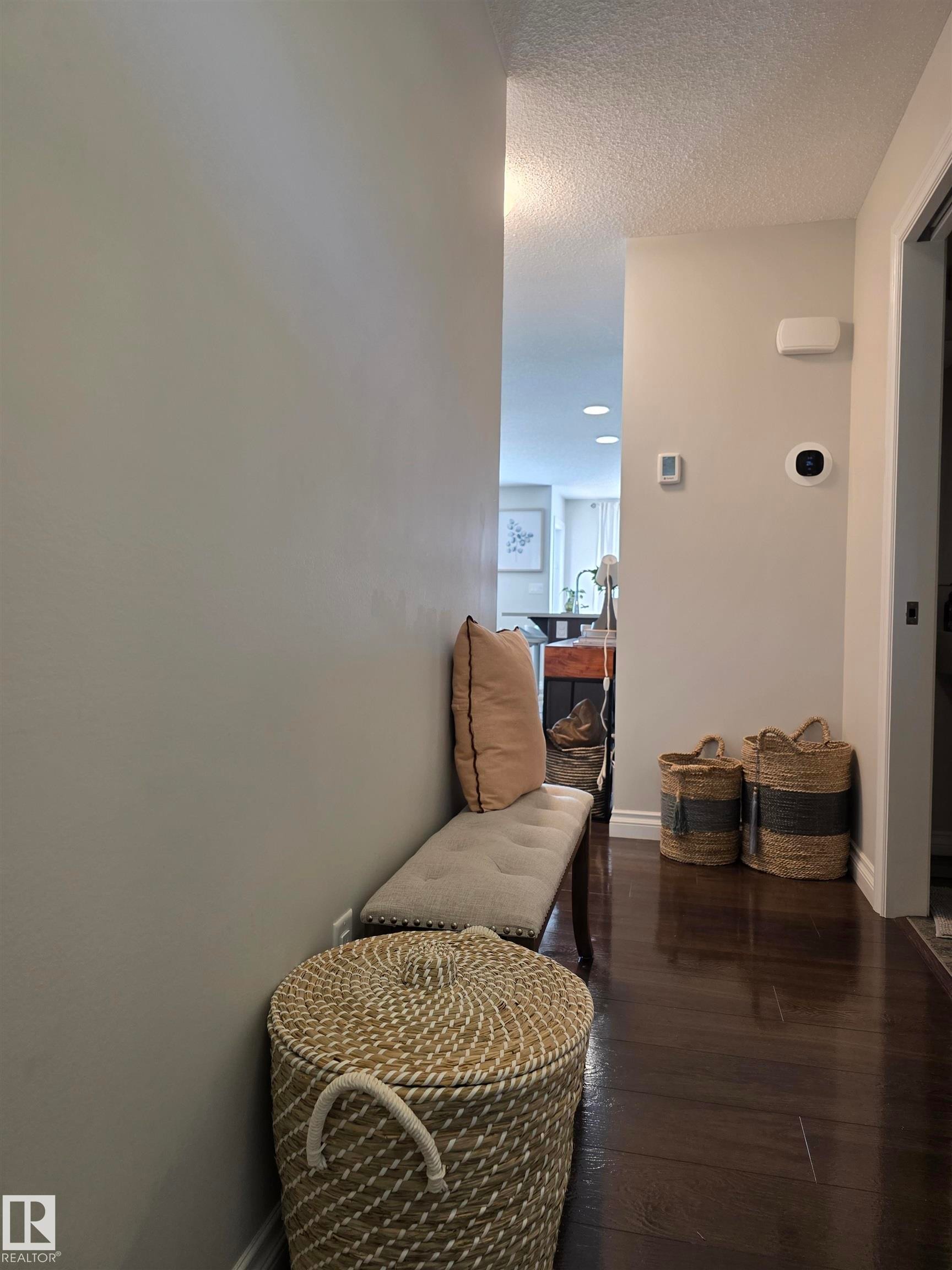 Rich wood-finish flooring extending through the hallway - 491 Ebbers Way, Edmonton, AB