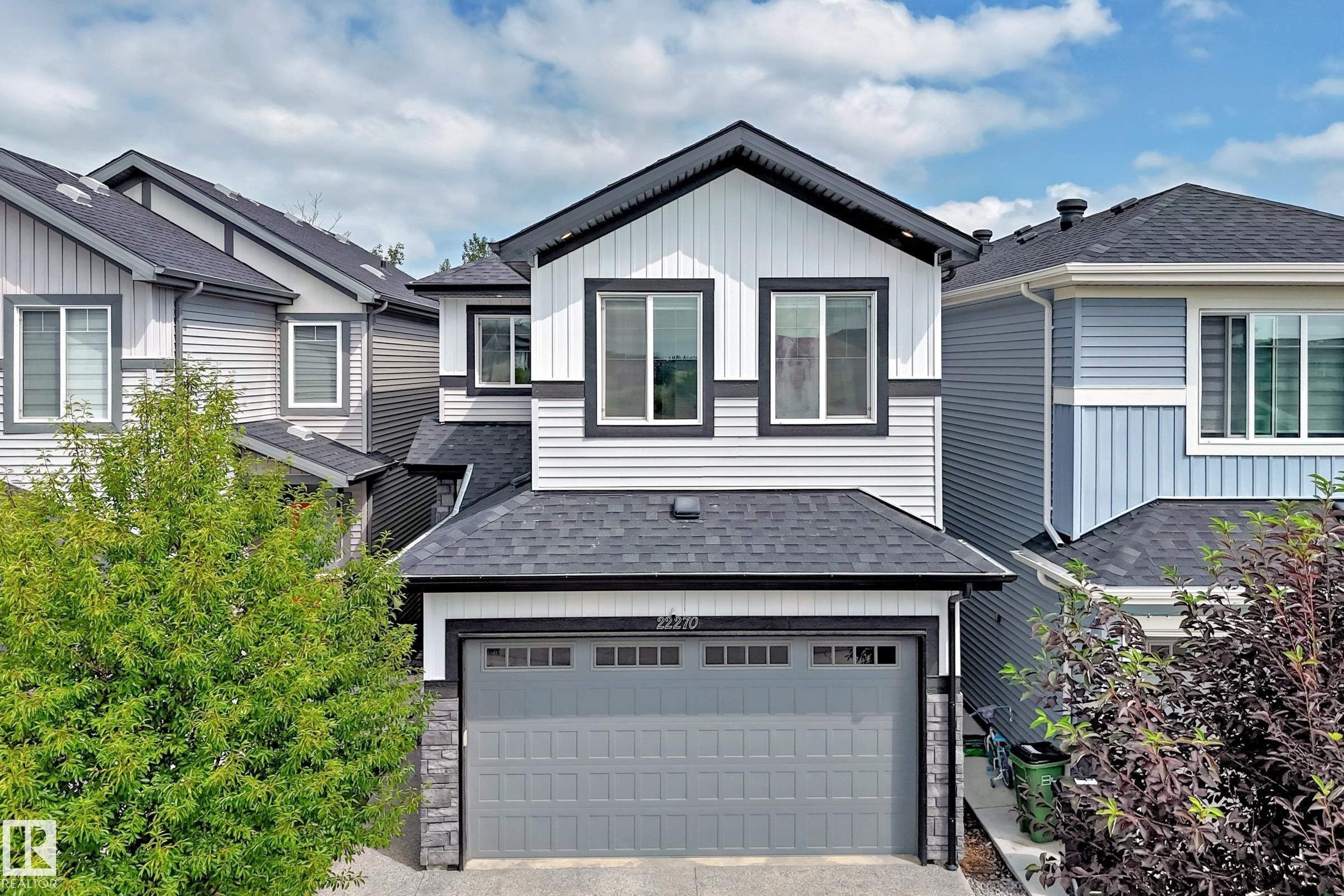 Contemporary exterior with varied siding, an attached garage, and multi-pane windows - 22270 99A Avenue Nw, Edmonton, AB - Outdoor