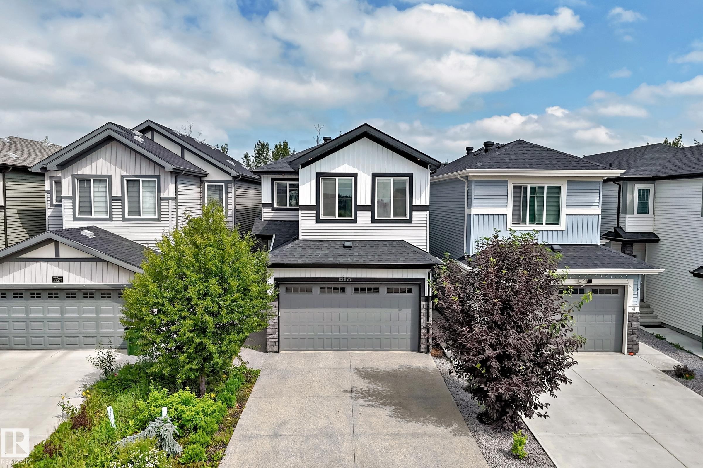 Modern two-story residence featuring a striking black and white exterior with vertical siding accents - 22270 99A Avenue Nw, Edmonton, AB - Outdoor With Facade