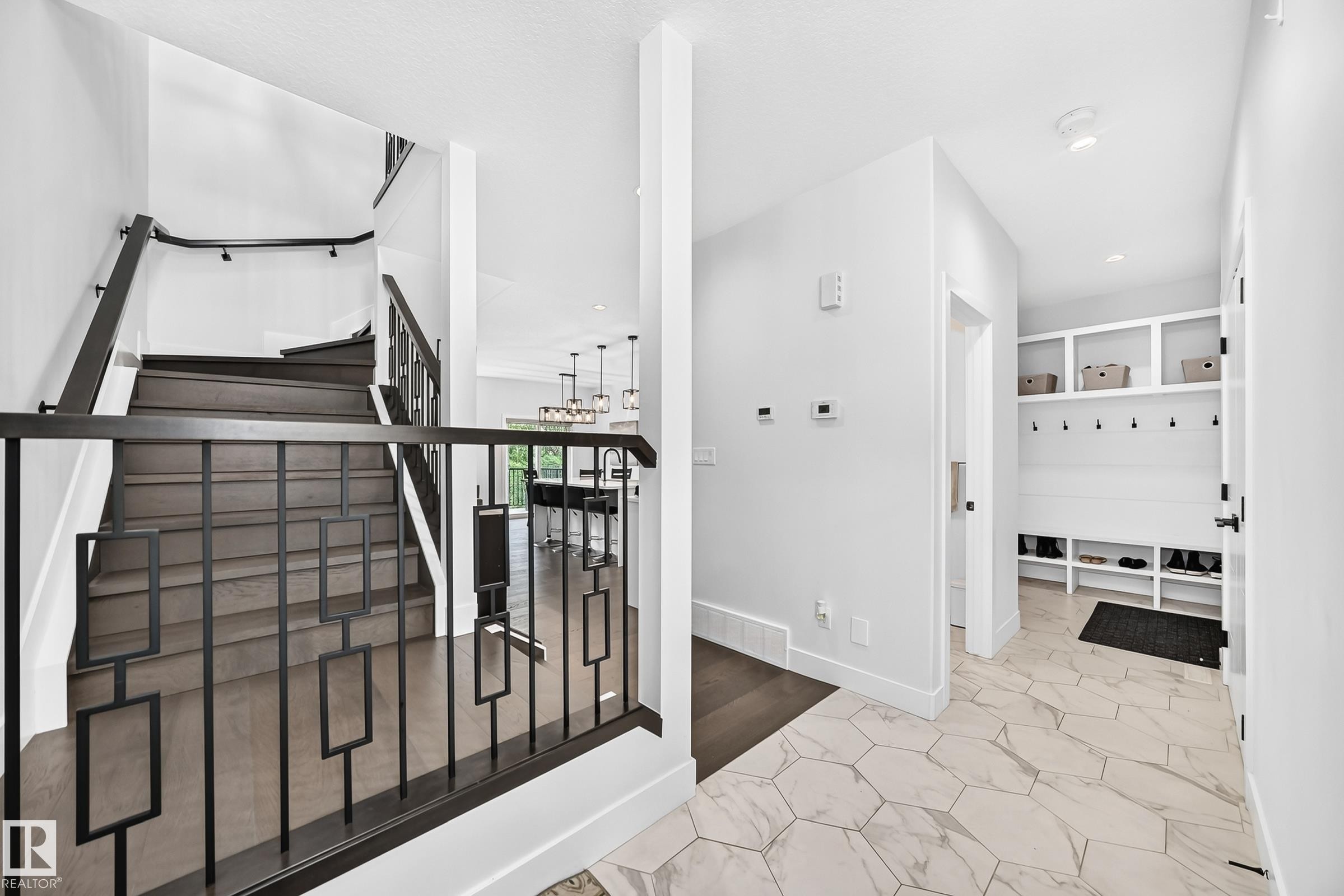 Hexagonal tile flooring, built-in mudroom storage, wood-finish flooring staircase, and contemporary black metal railings - 22270 99A Avenue Nw, Edmonton, AB - Indoor Photo Showing Other Room