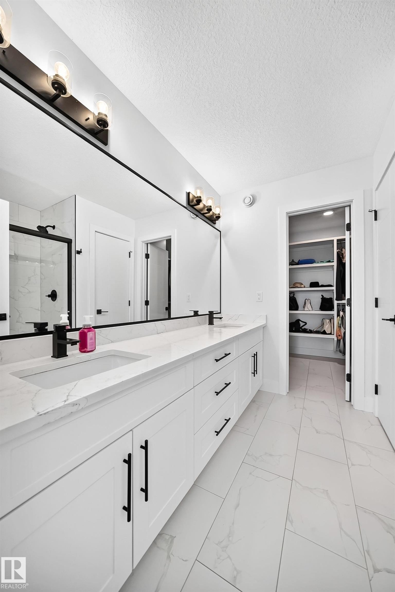 Double vanity featuring white cabinetry, integrated sinks, and black hardware - 22270 99A Avenue Nw, Edmonton, AB - Indoor Photo Showing Bathroom