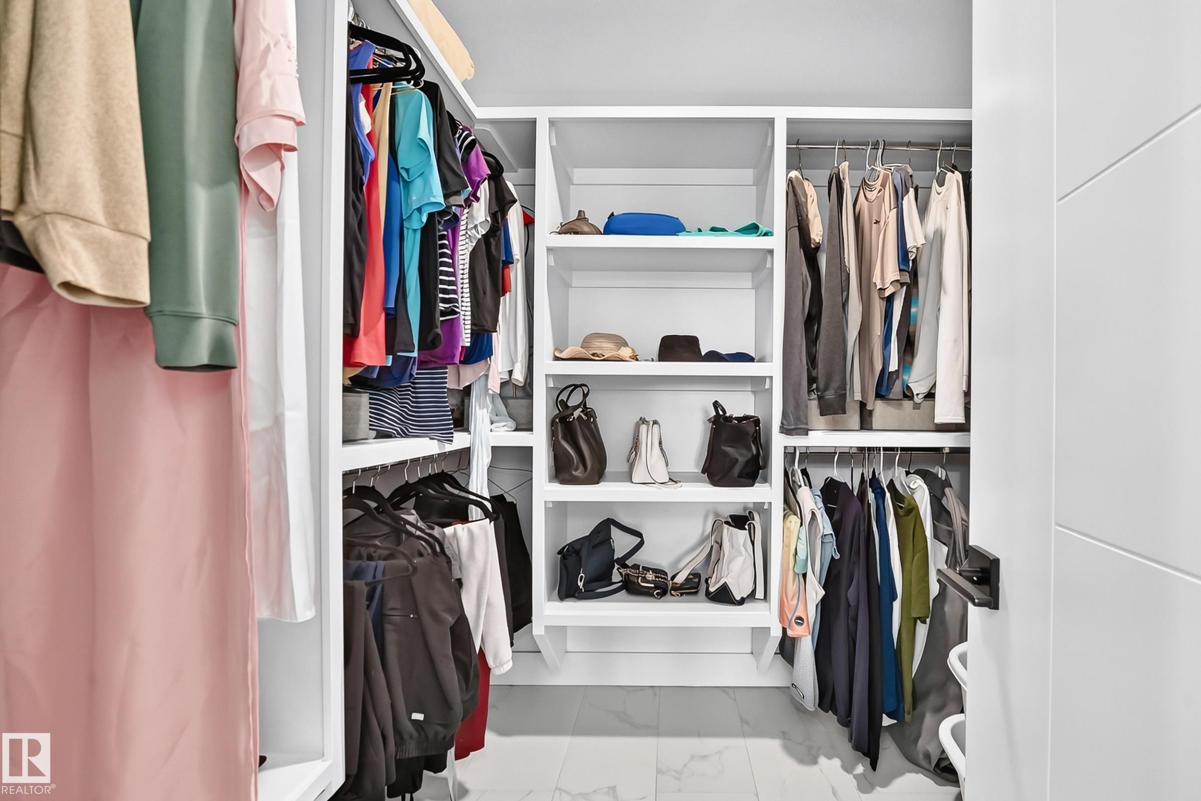 Integrated custom closet system featuring white shelving, multiple hanging rods, and open storage compartments - 22270 99A Avenue Nw, Edmonton, AB - Indoor With Storage