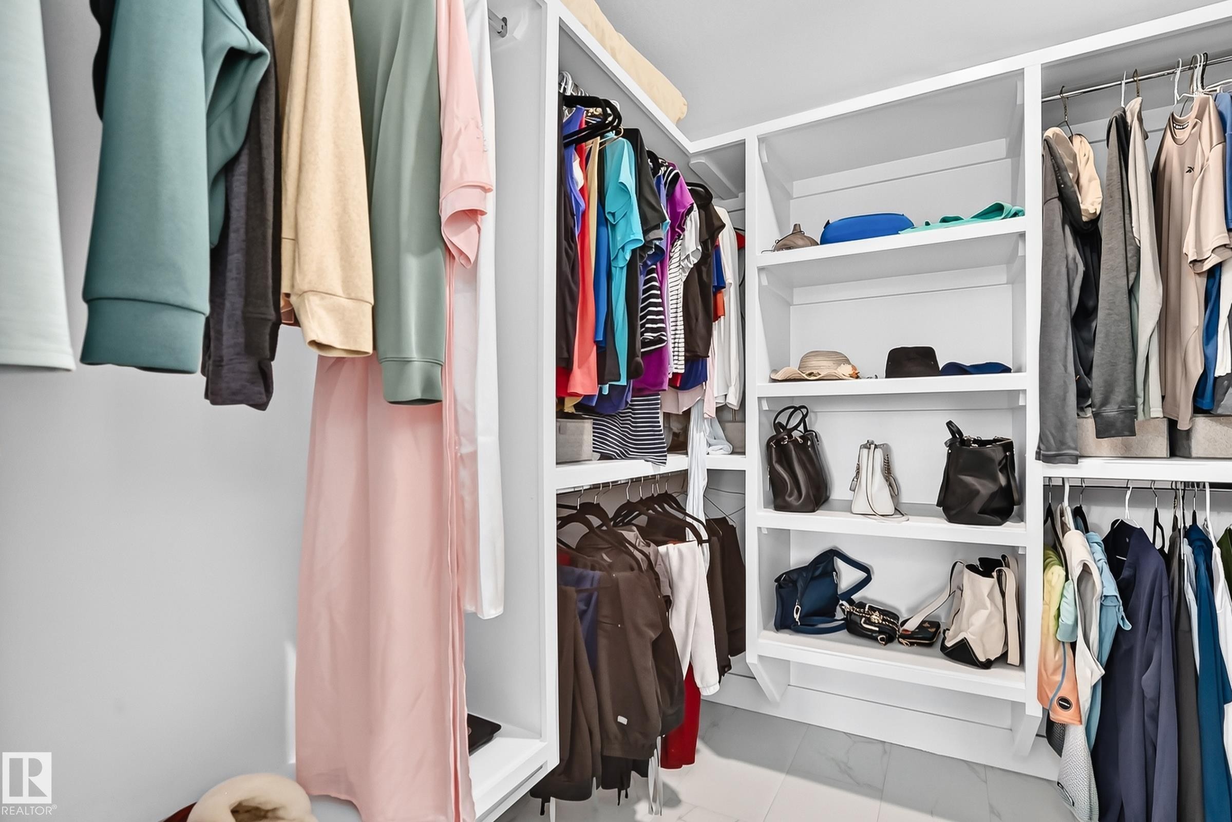 Integrated closet system featuring white shelving and chrome hanging rods - 22270 99A Avenue Nw, Edmonton, AB - Indoor With Storage