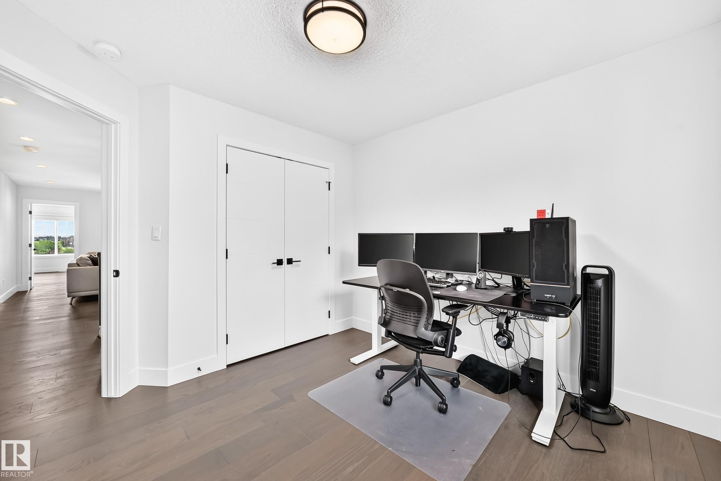 Room featuring wood-finish flooring, white walls, and a contemporary flush-mount ceiling light - 22270 99A Avenue Nw, Edmonton, AB - Indoor Photo Showing Office