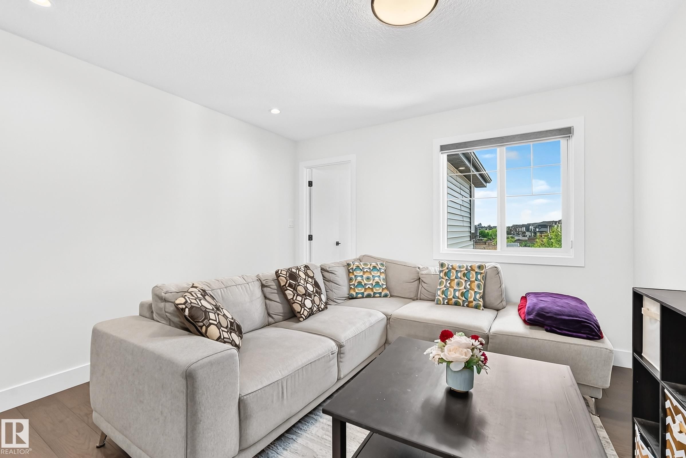 Bright room with white painted walls and dark wood-finish flooring - 22270 99A Avenue Nw, Edmonton, AB - Indoor Photo Showing Living Room