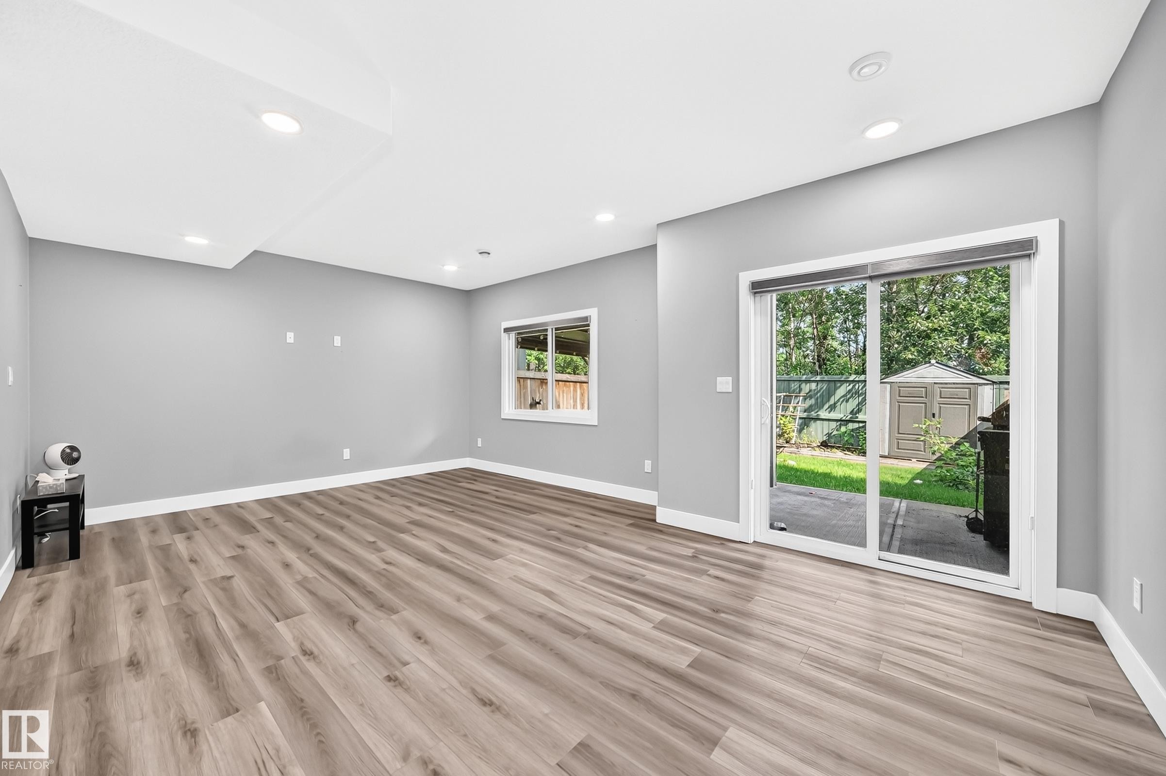 Spacious room featuring wood-finish flooring, recessed lighting, and a neutral wall color palette - 22270 99A Avenue Nw, Edmonton, AB - Indoor Photo Showing Other Room