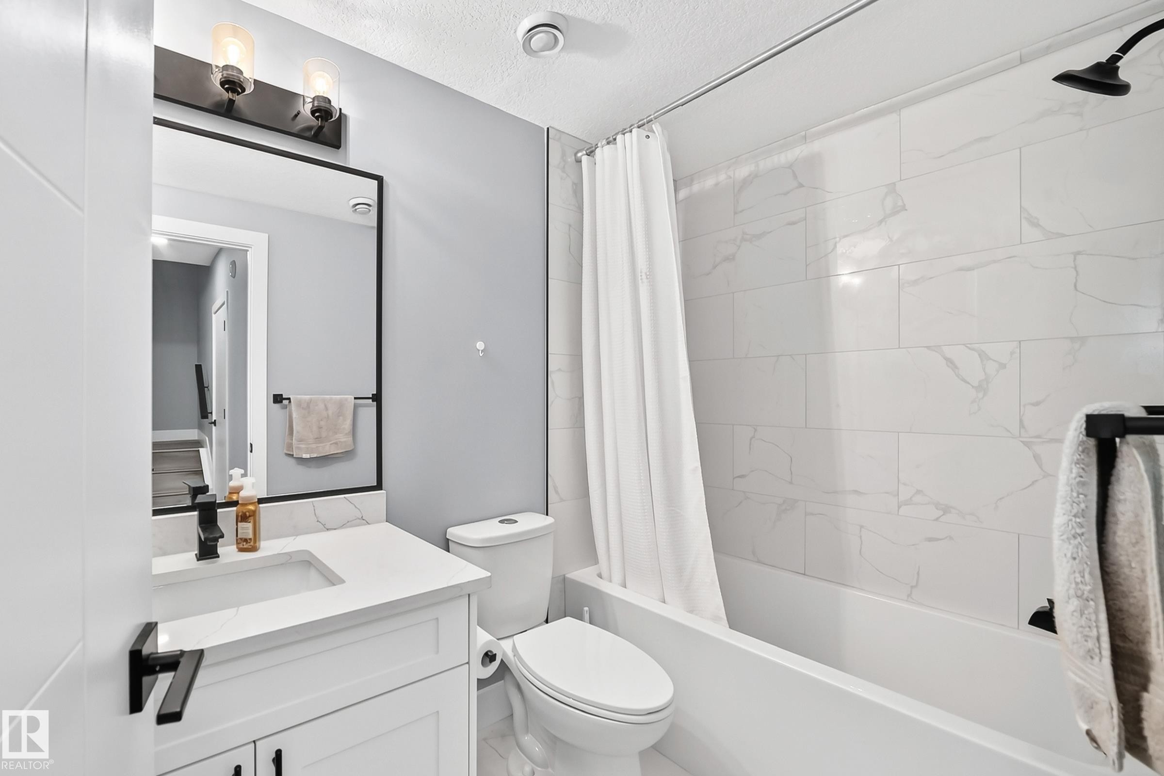 Full bathroom featuring a white vanity with a rectangular undermount sink, quartz countertop, and matte black fixtures - 22270 99A Avenue Nw, Edmonton, AB - Indoor Photo Showing Bathroom
