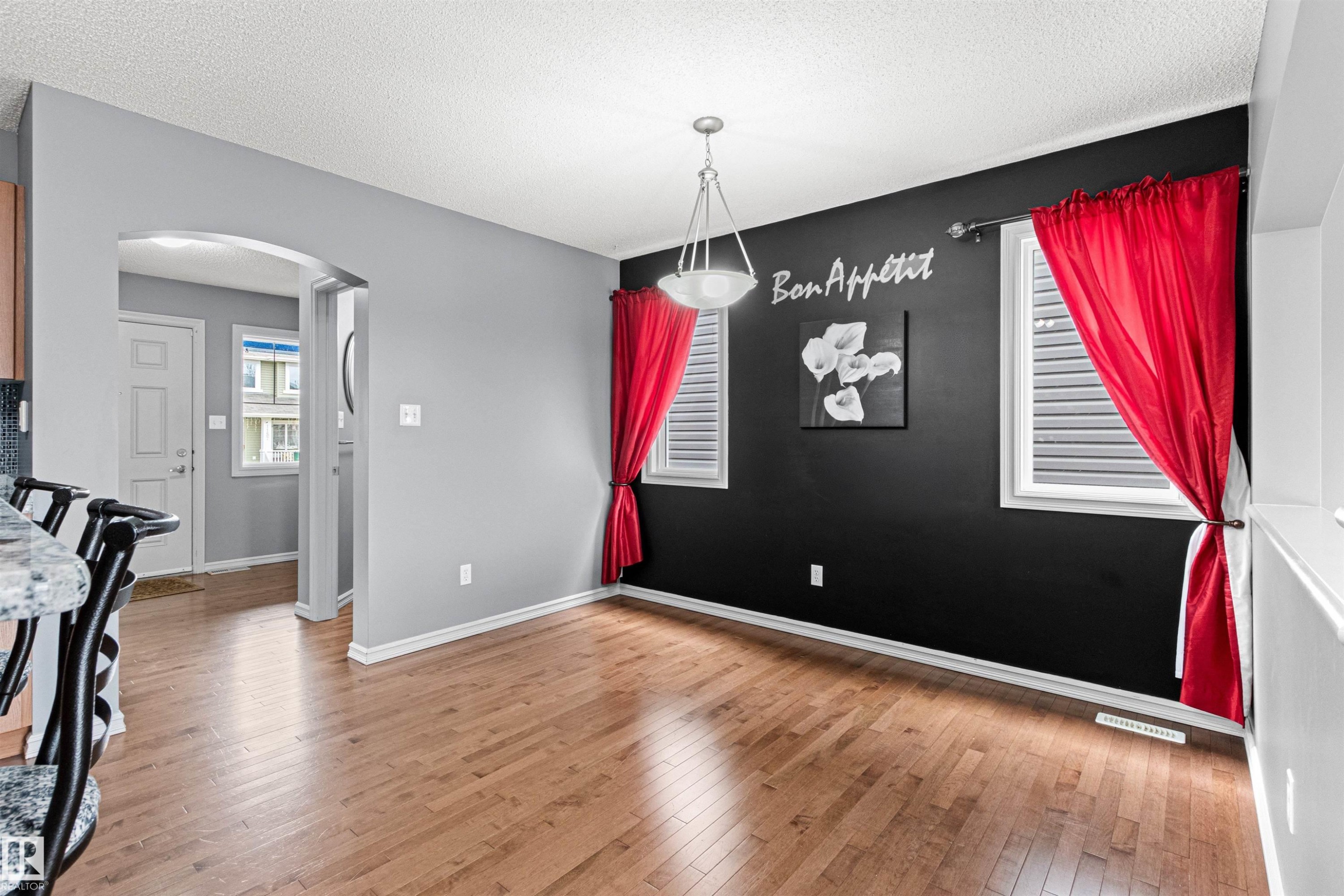 Dining area featuring wood-finish flooring, a contemporary ceiling light fixture, and two windows with horizontal blinds - 1154 35A Avenue Nw, Edmonton, AB - Indoor Photo Showing Other Room