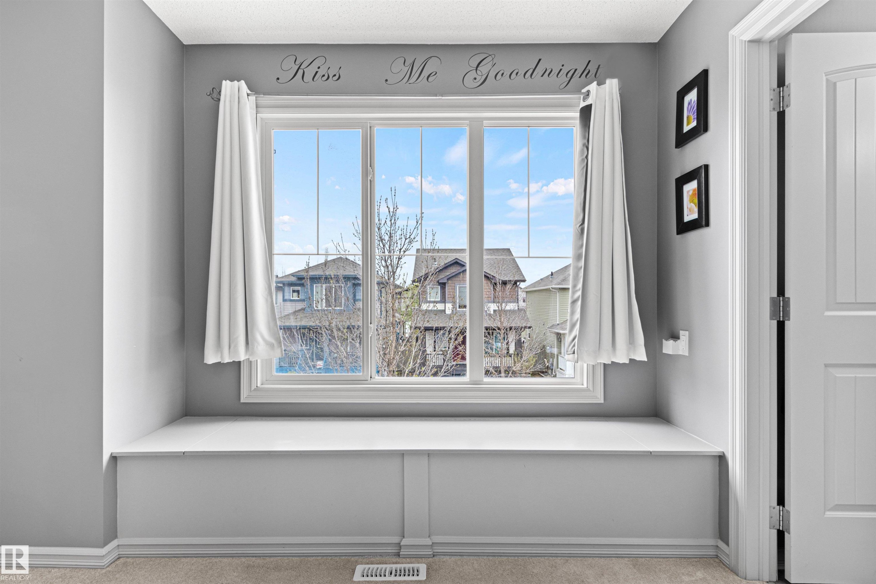 Built-in window bench with a large multi-pane window, light gray walls, and light-toned carpet flooring - 1154 35A Avenue Nw, Edmonton, AB - Indoor Photo Showing Other Room