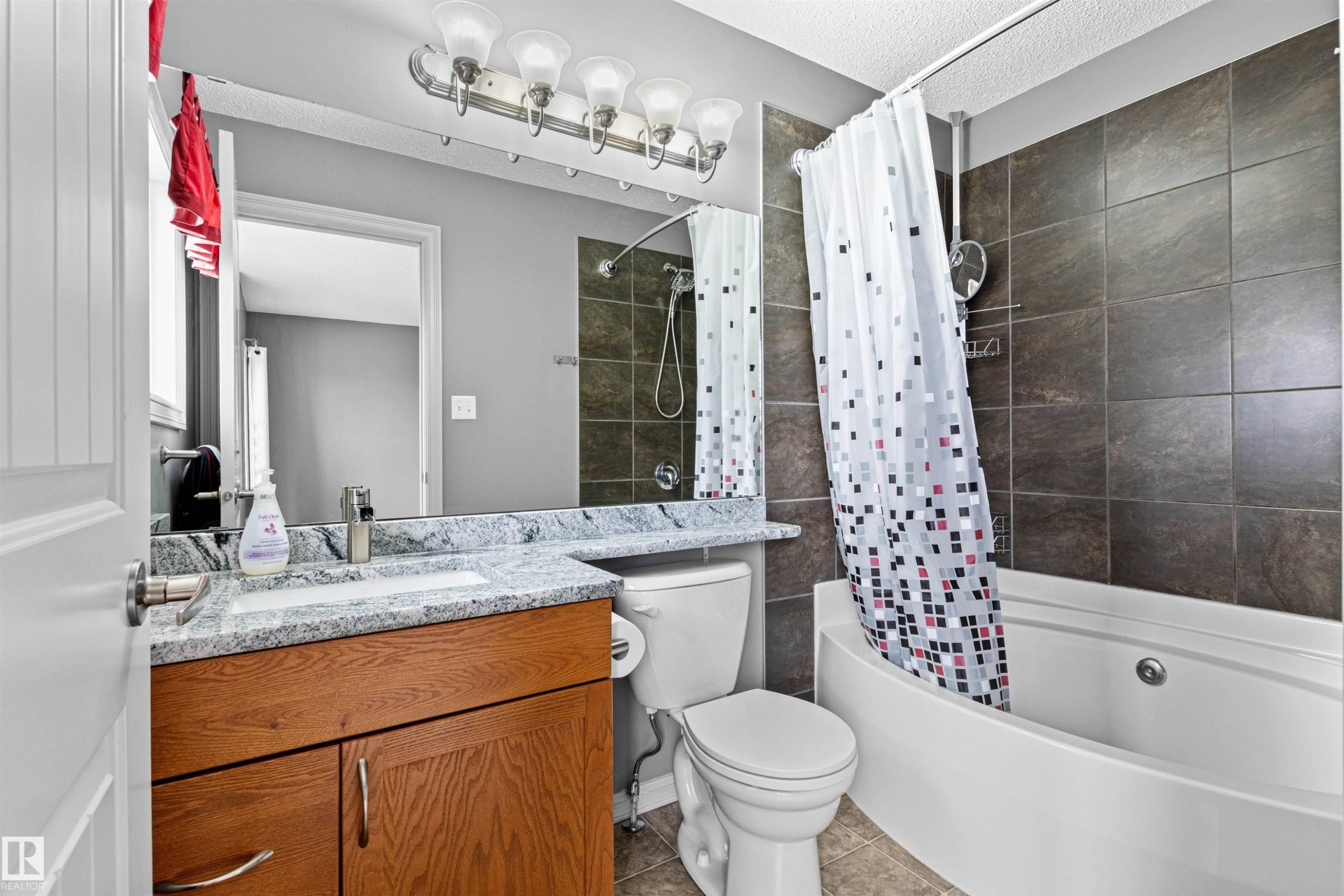 Bathroom featuring a wood-finish vanity with a granite countertop and undermount sink - 1154 35A Avenue Nw, Edmonton, AB - Indoor Photo Showing Bathroom