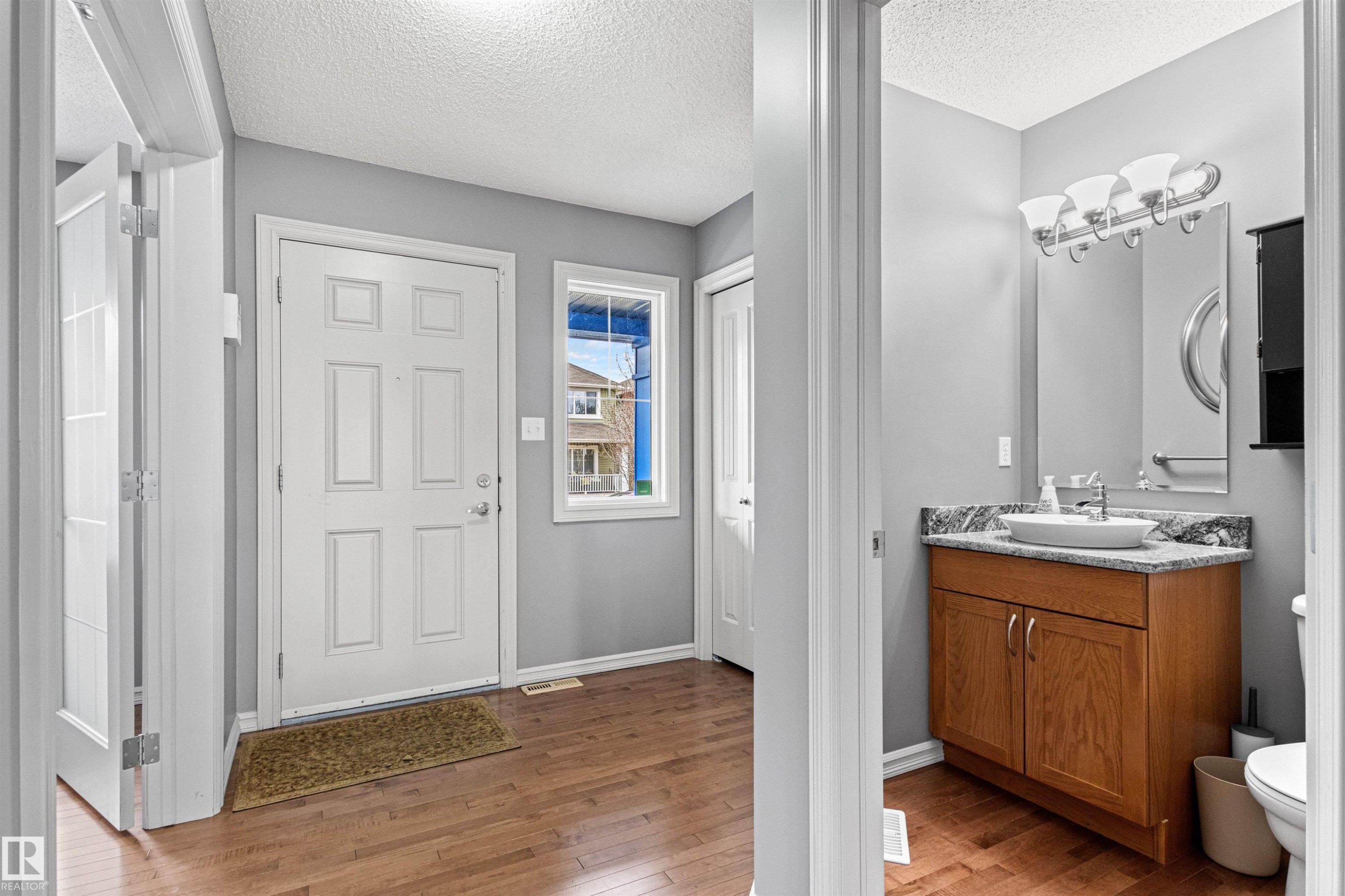 Entryway featuring wood-finish flooring and a six-panel door - 1154 35A Avenue Nw, Edmonton, AB - Indoor Photo Showing Bathroom