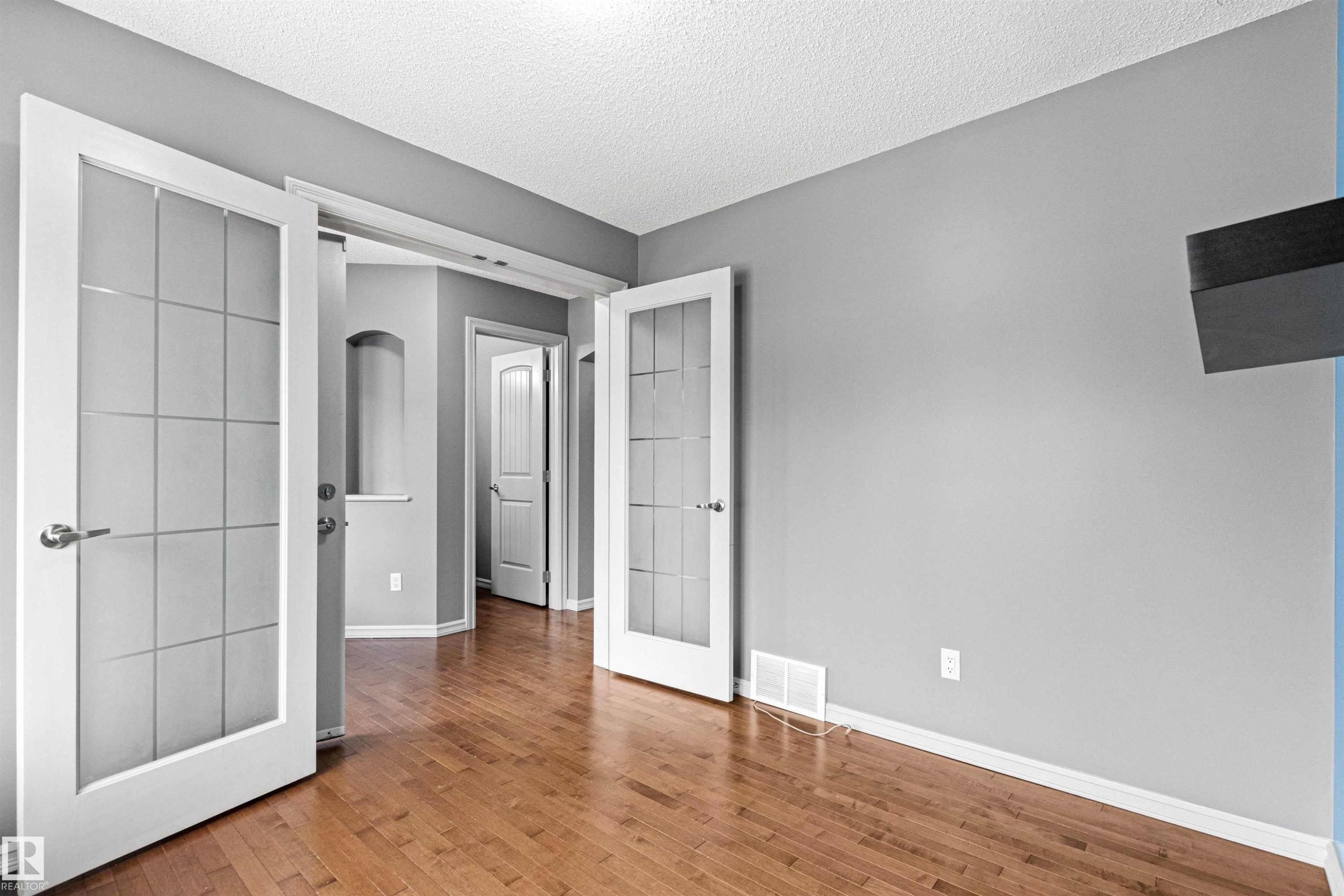 Interior room featuring wood-finish flooring, light gray wall paint, and white trim - 1154 35A Avenue Nw, Edmonton, AB - Indoor Photo Showing Other Room