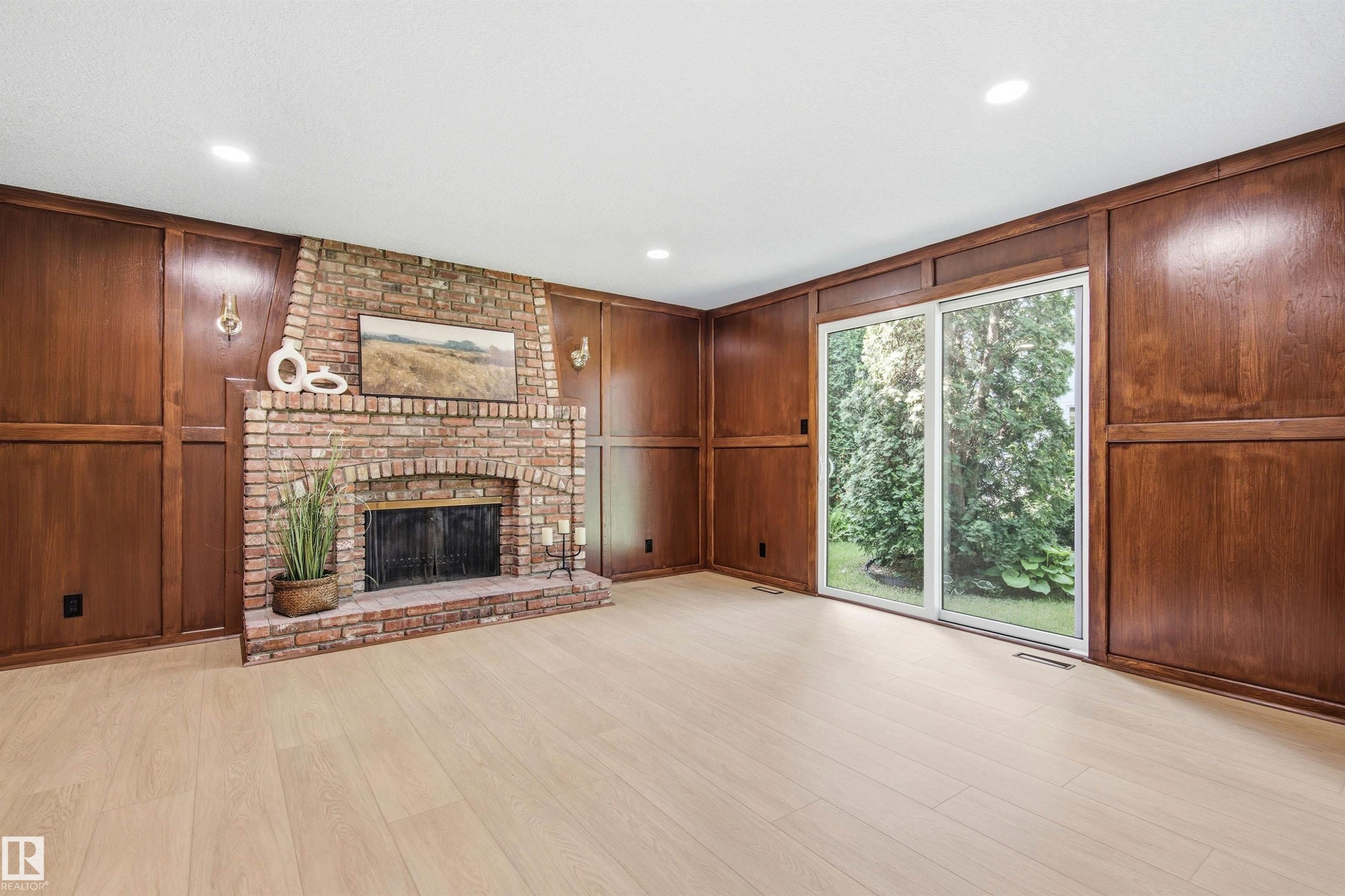 Brick fireplace with an arched firebox and hearth, surrounded by extensive wood paneling - 14335 47 Avenue Nw, Edmonton, AB - Indoor With Fireplace