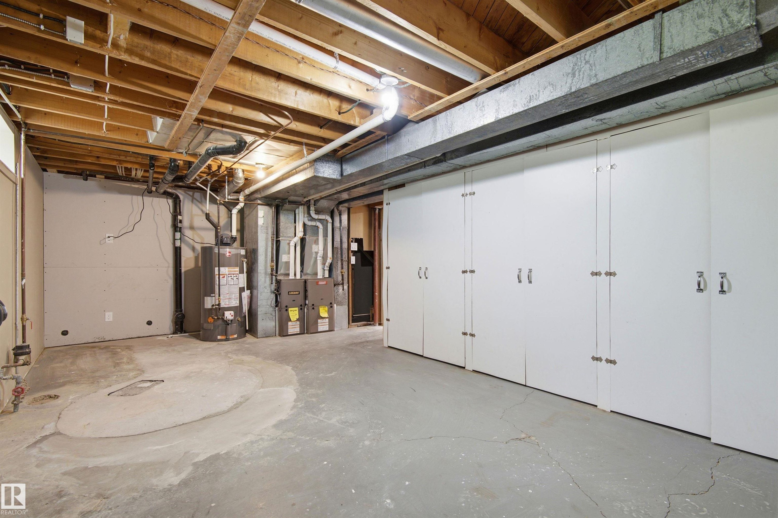 Spacious basement with exposed ceiling joists and concrete flooring - 14335 47 Avenue Nw, Edmonton, AB - Indoor Photo Showing Basement