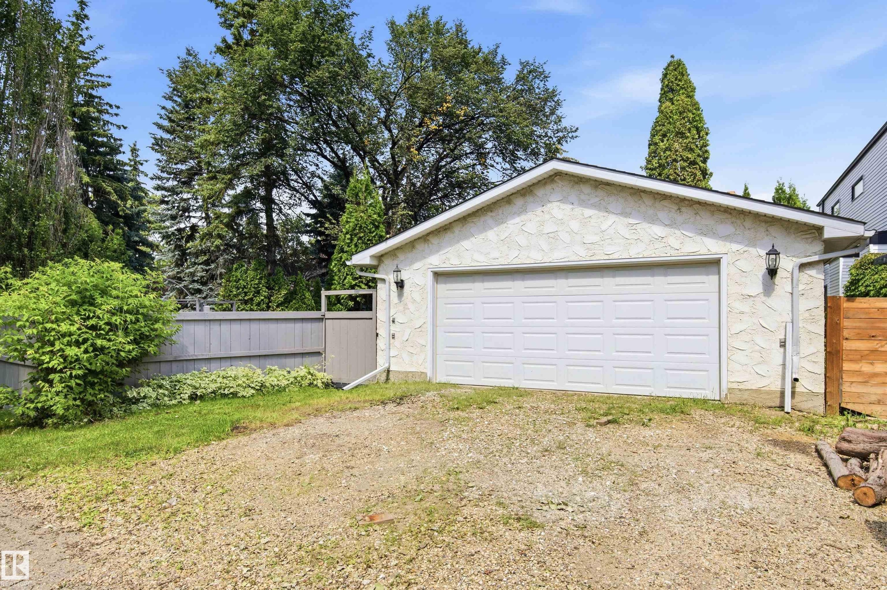 Detached garage featuring a white panel door and textured exterior finish - 14335 47 Avenue Nw, Edmonton, AB - Outdoor