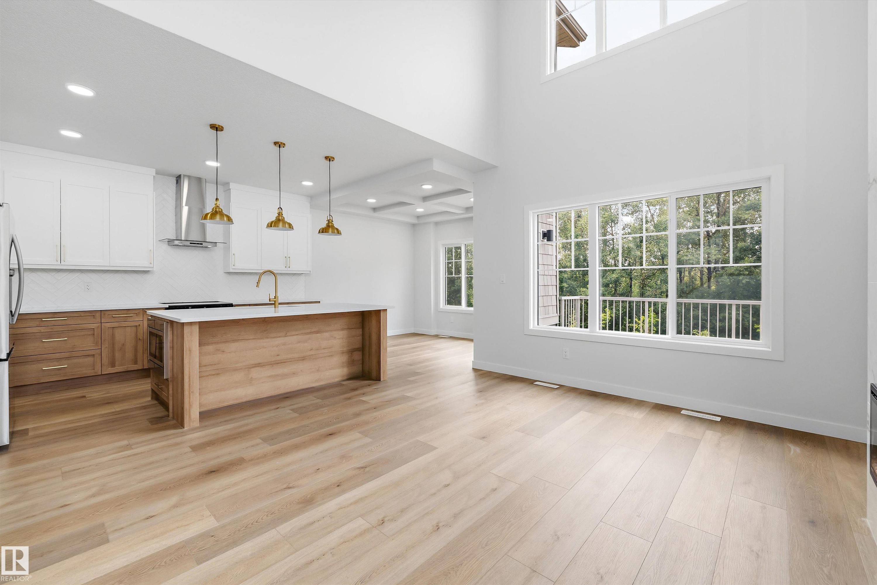Open-concept living area featuring high ceilings, wood-finish flooring, and expansive windows - 919 Elderberry Landing Nw, Edmonton, AB - Indoor