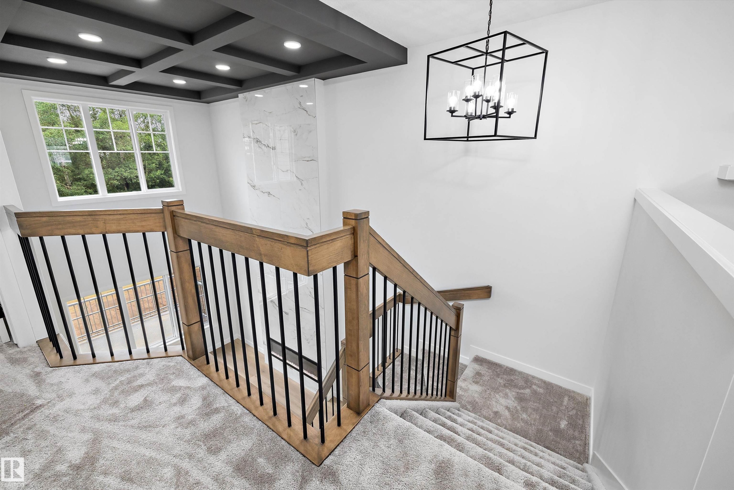 Upper-level landing featuring a coffered ceiling with recessed lighting, an expansive window, and a contemporary chandelier - 919 Elderberry Landing Nw, Edmonton, AB - Indoor Photo Showing Other Room