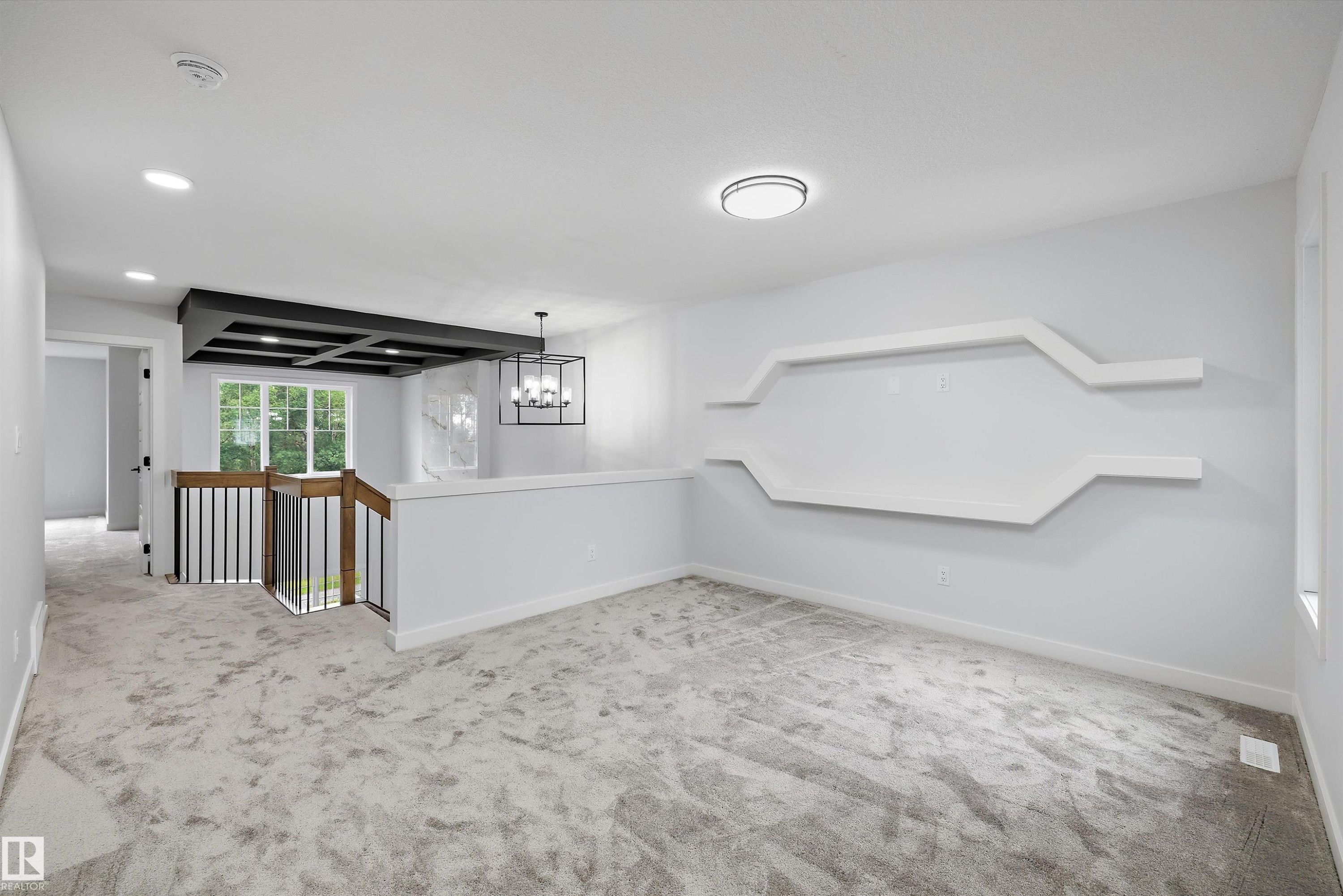 Carpeted space featuring a geometric wall display, recessed lighting, and a modern ceiling fixture - 919 Elderberry Landing Nw, Edmonton, AB - Indoor Photo Showing Other Room