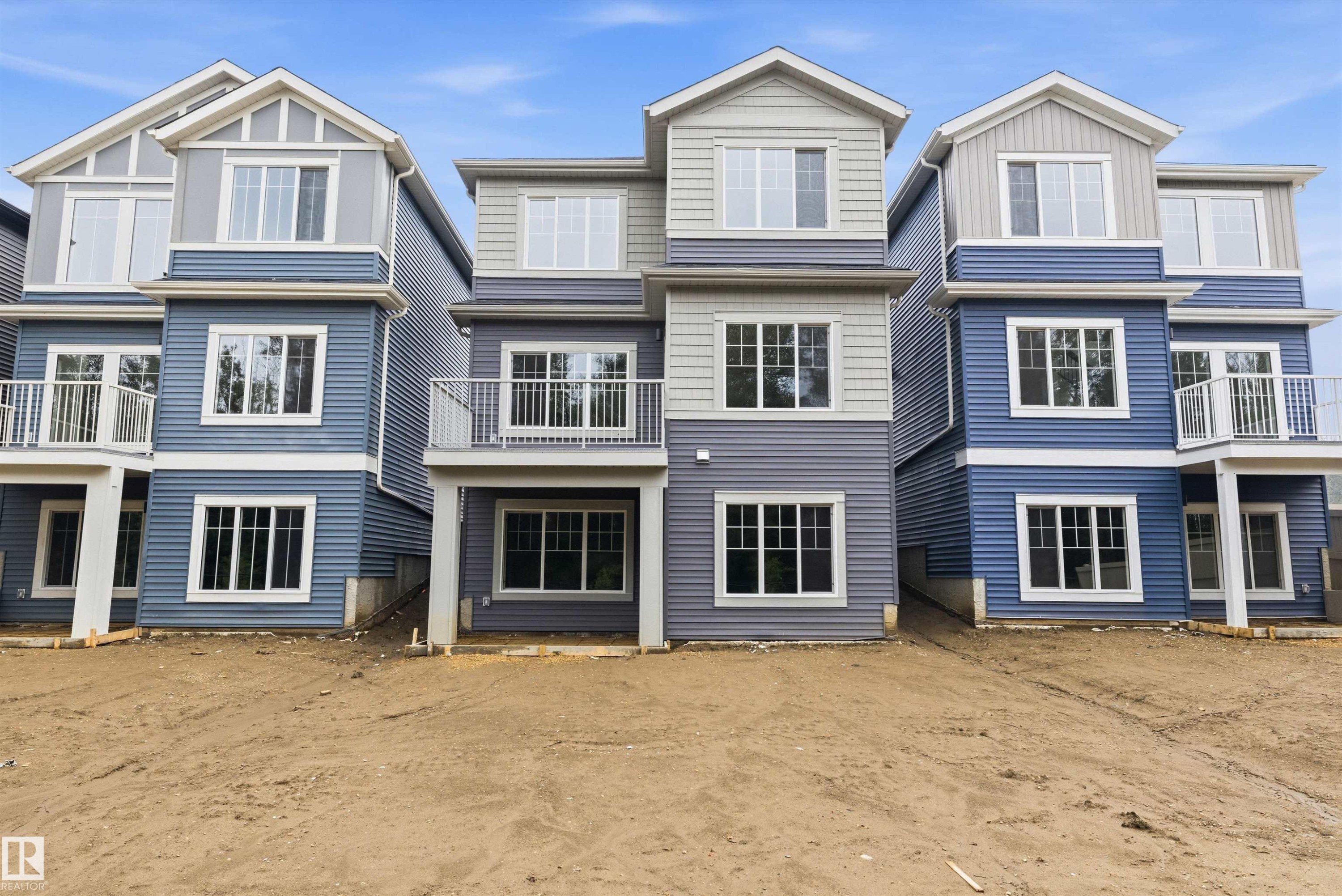 Three-story townhome featuring multi-toned siding, white trim, and a second-story balcony with white railings - 919 Elderberry Landing Nw, Edmonton, AB - Outdoor With Facade