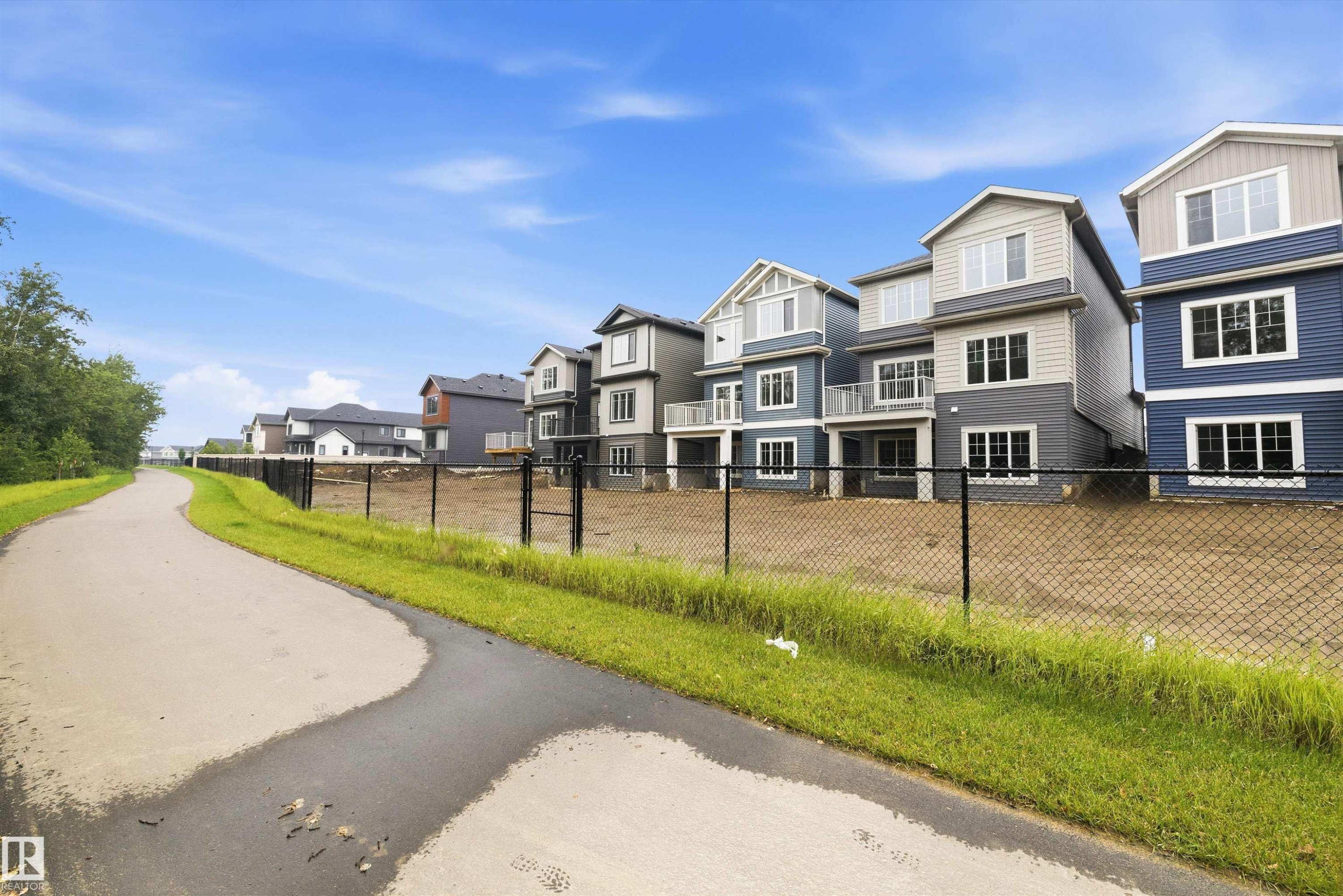 Row of residences featuring multi-level designs and varied siding colors, including shades of blue and gray - 919 Elderberry Landing Nw, Edmonton, AB - Outdoor