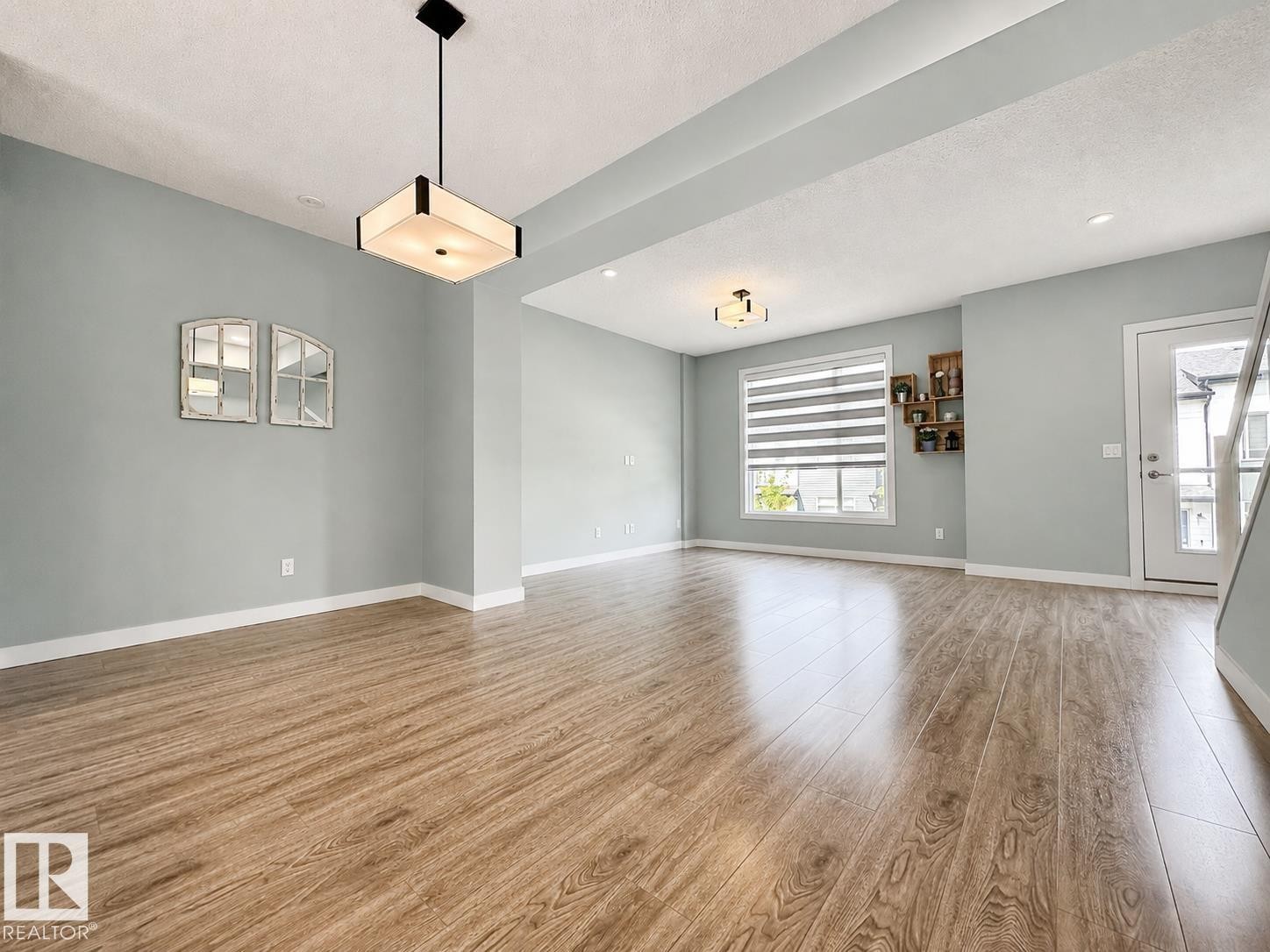 Open concept living space featuring wood-finish flooring, light gray walls, and white trim - #56 804 Welsh Dr Sw, Edmonton, AB - Indoor