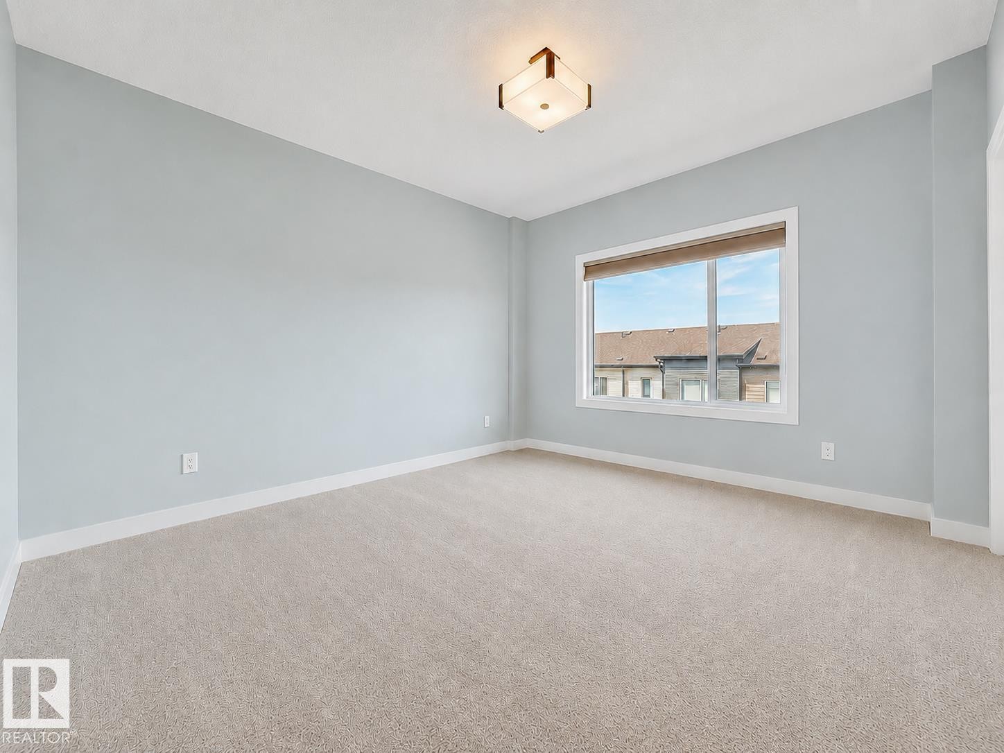 Recessed window with white trim, light blue wall paint, and light-colored carpeting - #56 804 Welsh Dr Sw, Edmonton, AB - Indoor Photo Showing Other Room
