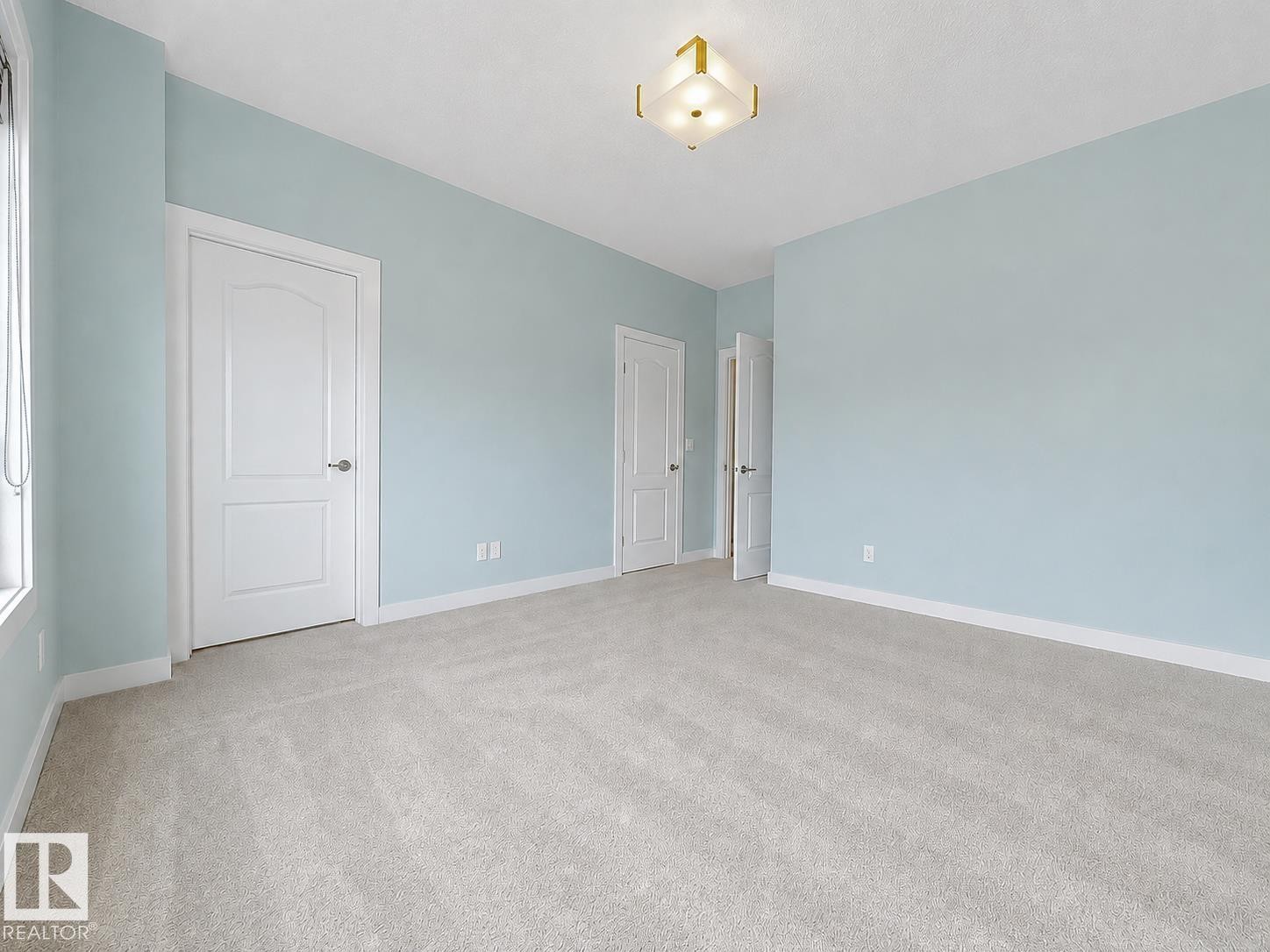 Light gray wall-to-wall carpeting, white trim, and a semi-flush mount ceiling light fixture - #56 804 Welsh Dr Sw, Edmonton, AB - Indoor Photo Showing Other Room