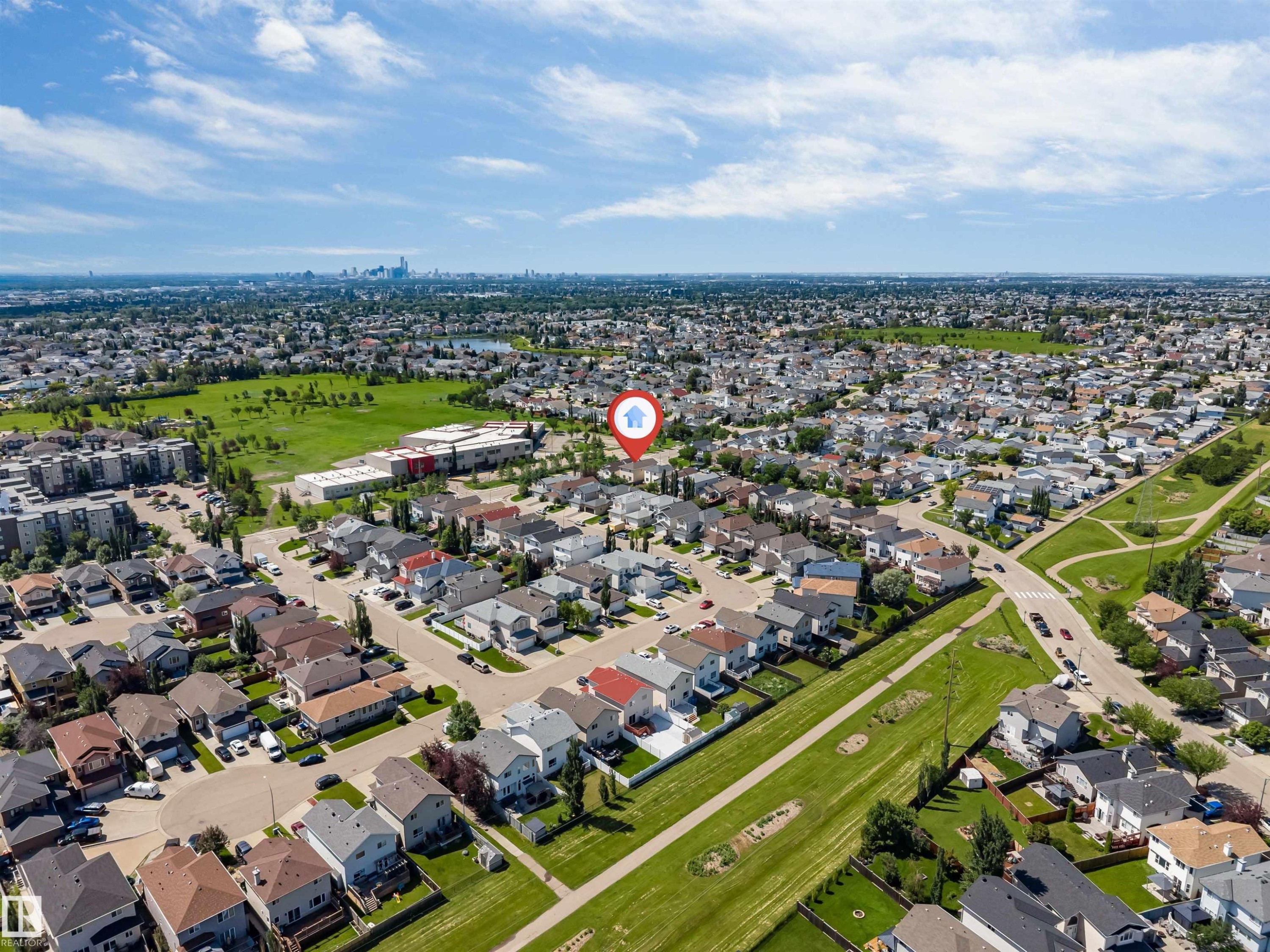 Aerial view of a residential neighborhood with detached homes, green spaces, and community infrastructure - 16205 55 Street Nw, Edmonton, AB - Outdoor With View