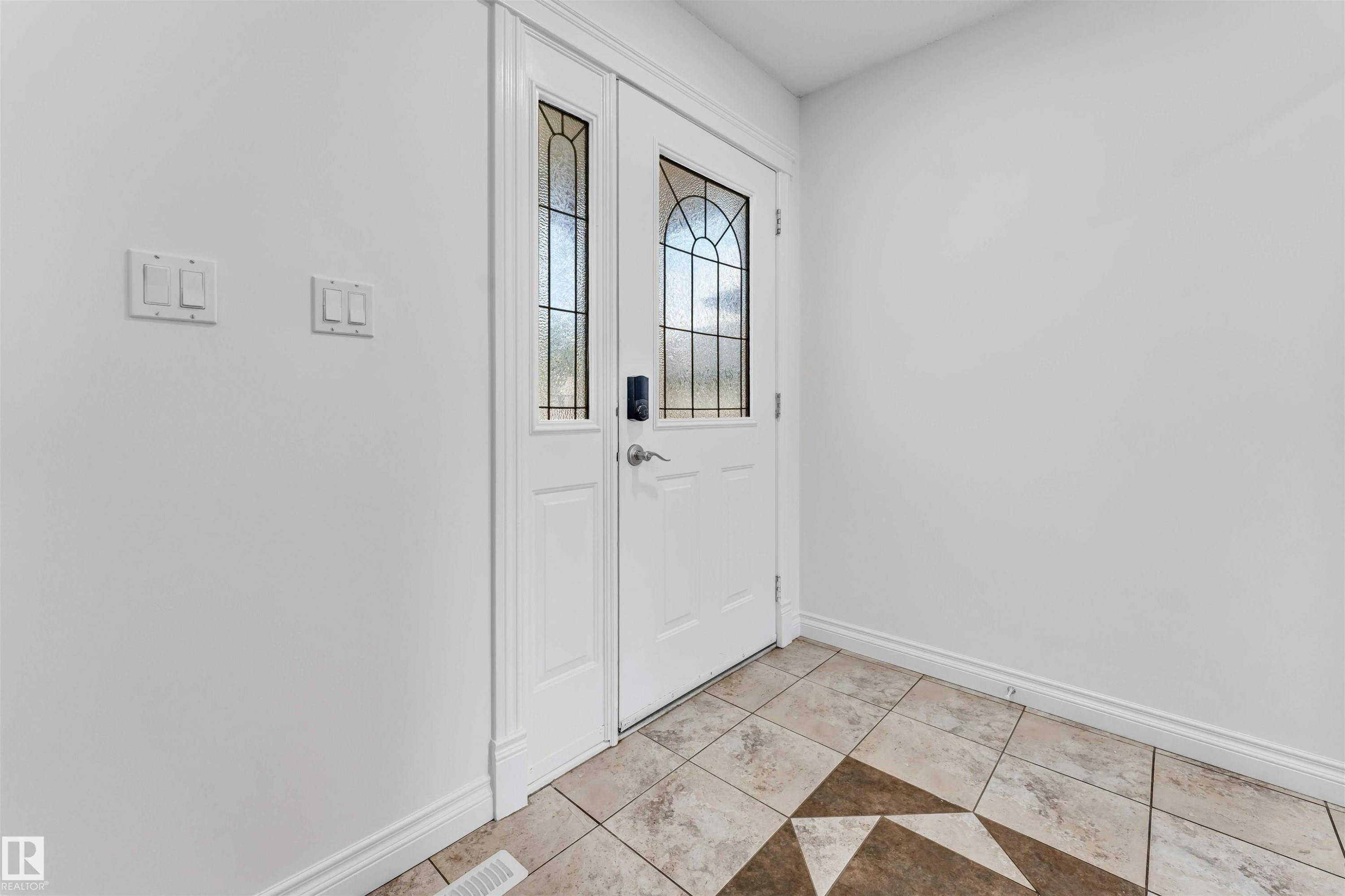 Double entry doors with decorative glass panels and a digital lock - 16205 55 Street Nw, Edmonton, AB - Indoor Photo Showing Other Room