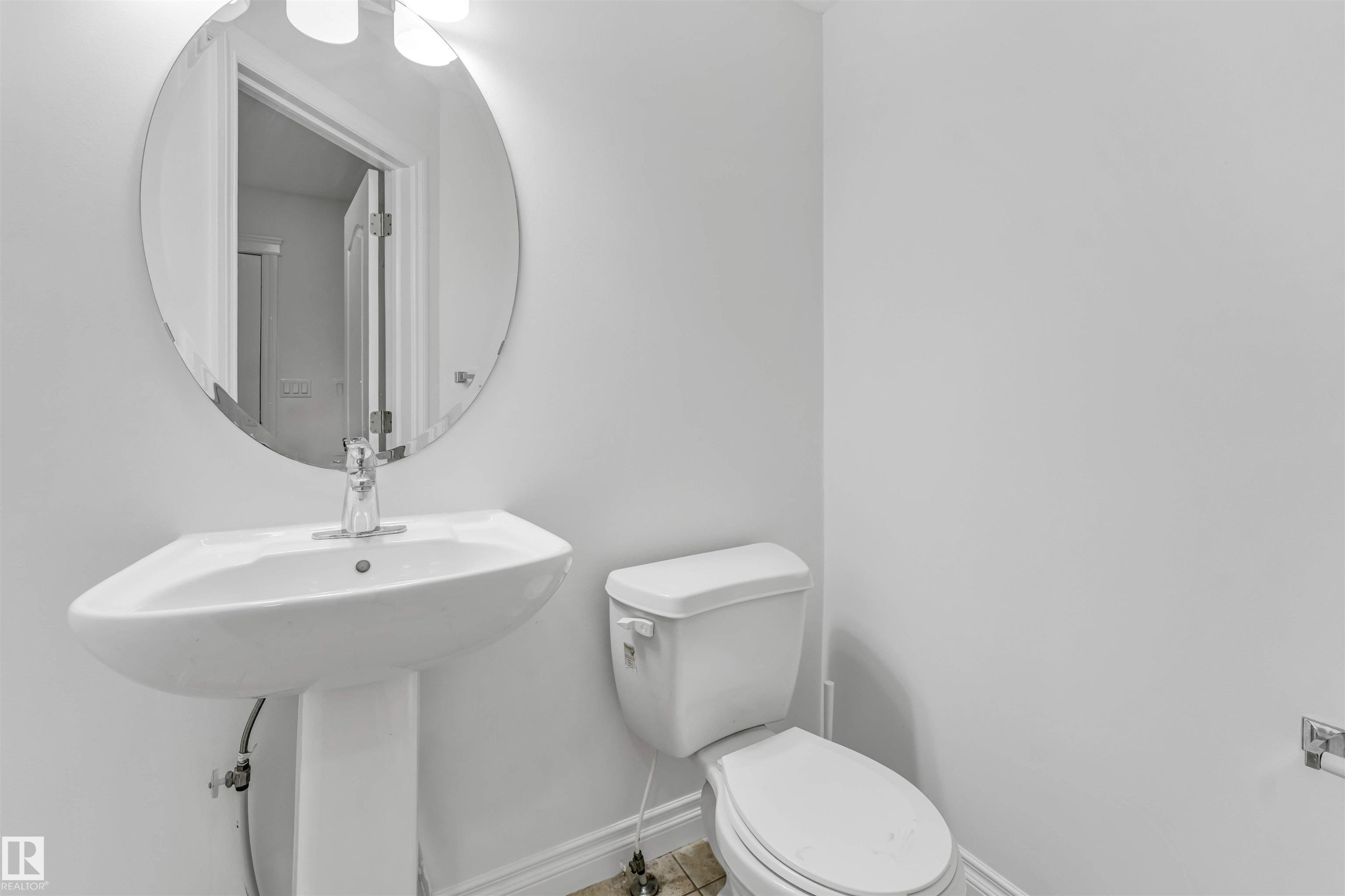 White pedestal sink with a chrome faucet - 16205 55 Street Nw, Edmonton, AB - Indoor Photo Showing Bathroom