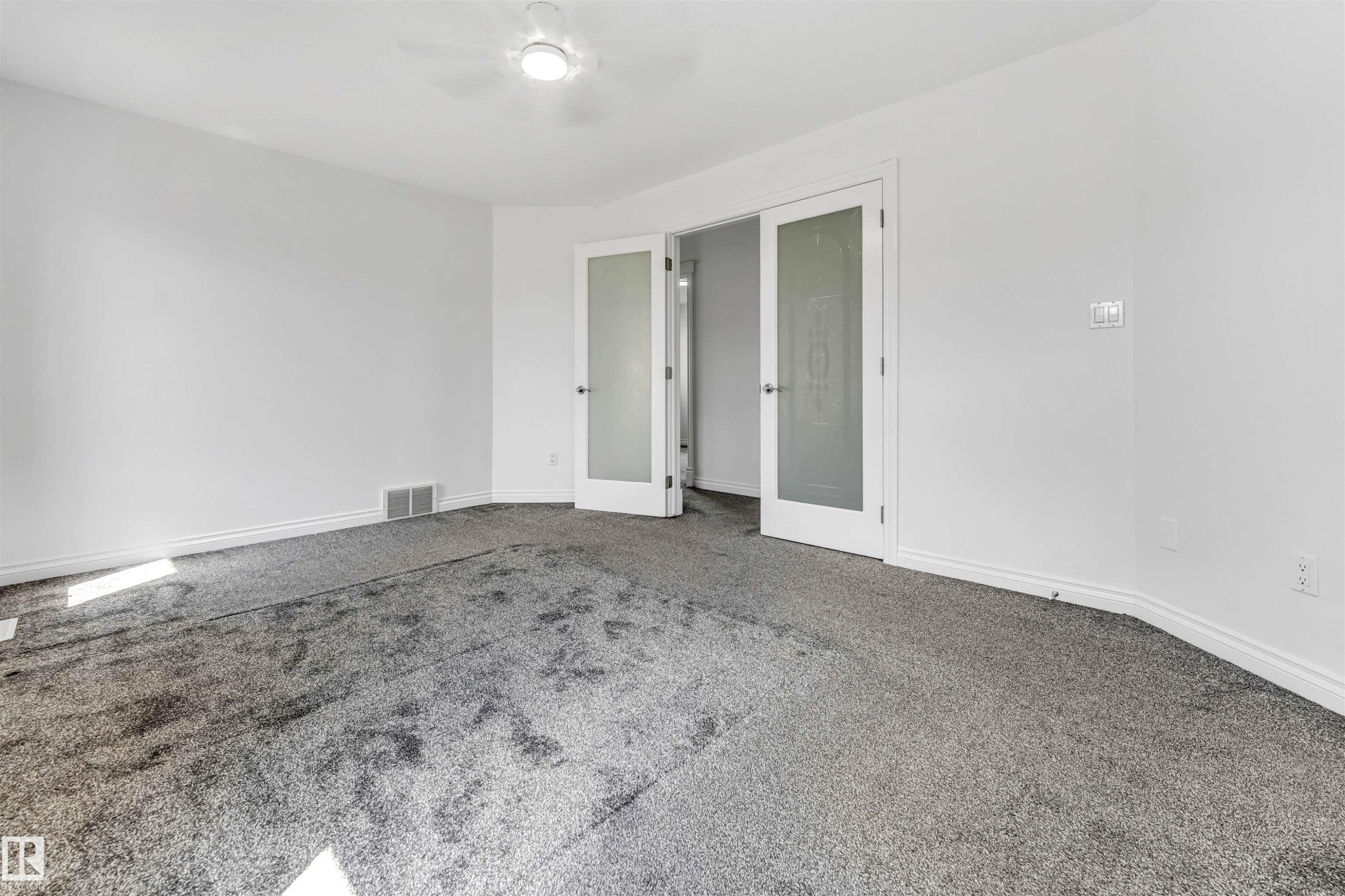 Spacious room featuring neutral carpeting and white painted walls - 16205 55 Street Nw, Edmonton, AB - Indoor Photo Showing Other Room