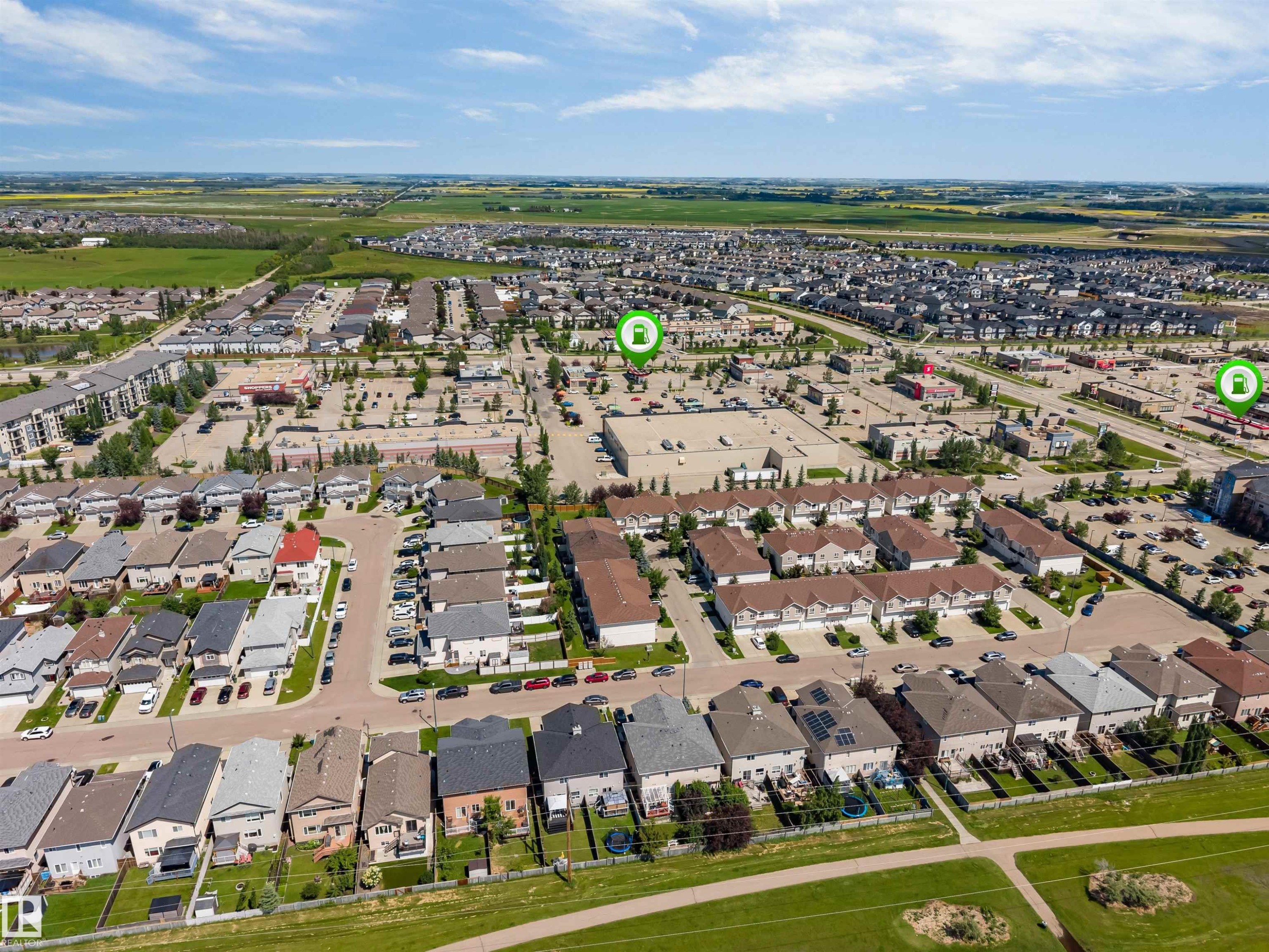 Aerial overview of a residential area featuring single-family homes and multi-unit dwellings - 16205 55 Street Nw, Edmonton, AB - Outdoor With View