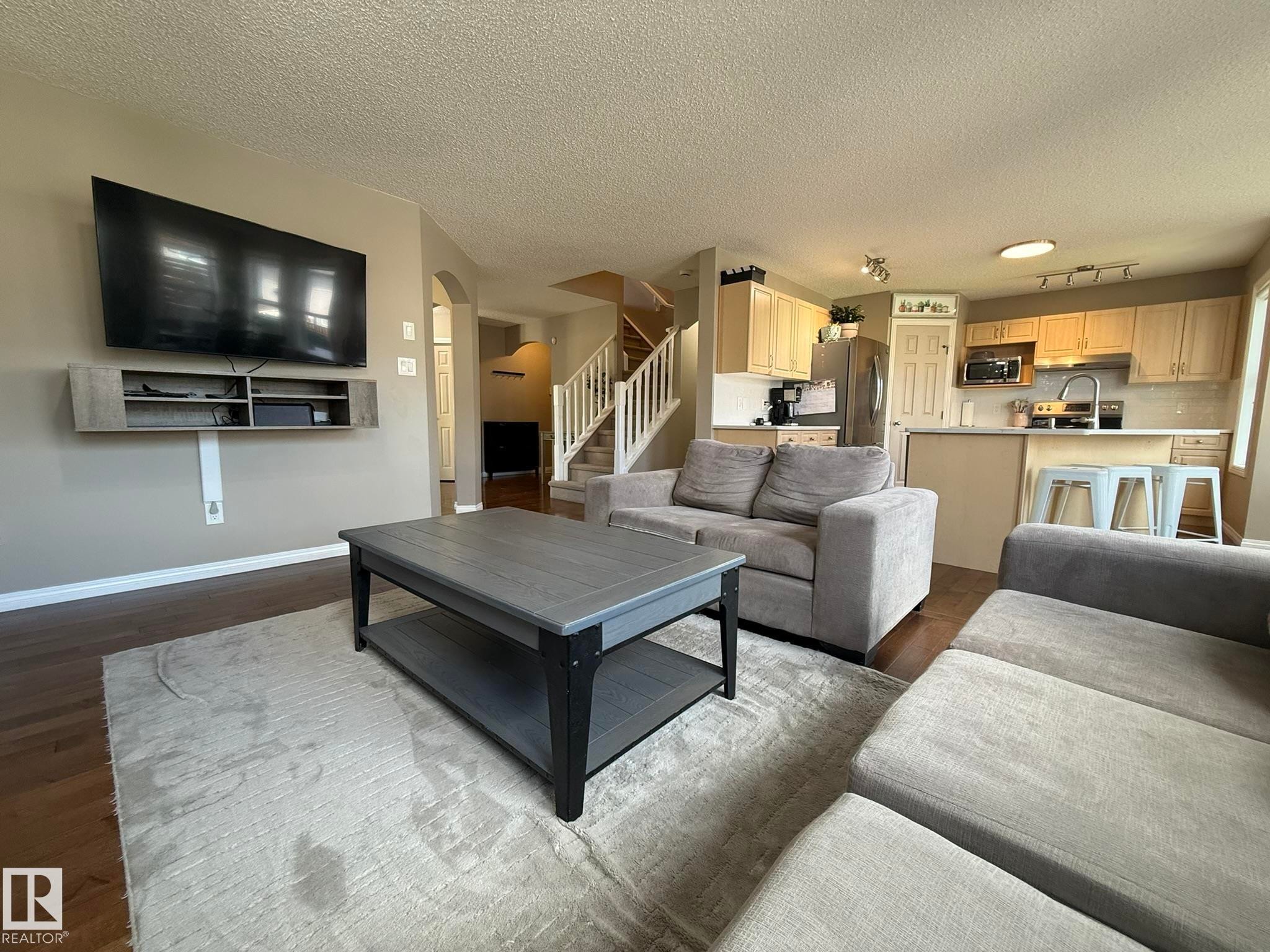 Open-concept living space featuring wood-finish flooring and neutral-toned walls - 1820 Robertson Crescent Sw, Edmonton, AB - Indoor Photo Showing Living Room